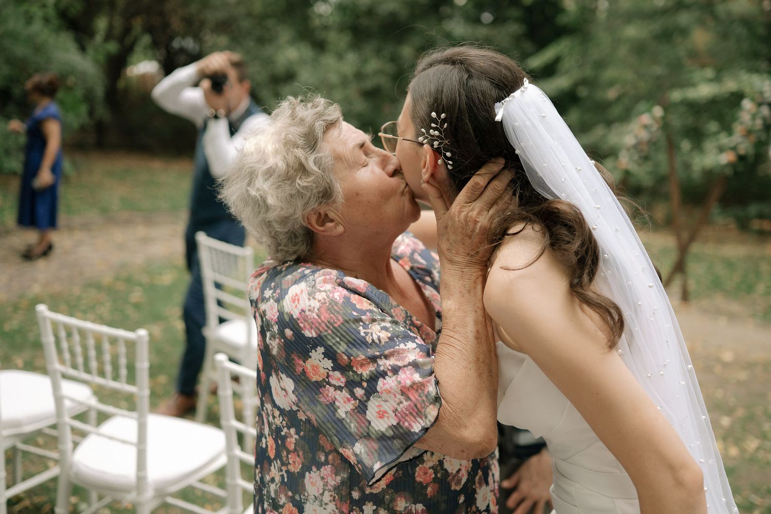 Joyful wedding celebration in a garden setting with guests and white chairs arranged for the ceremony.