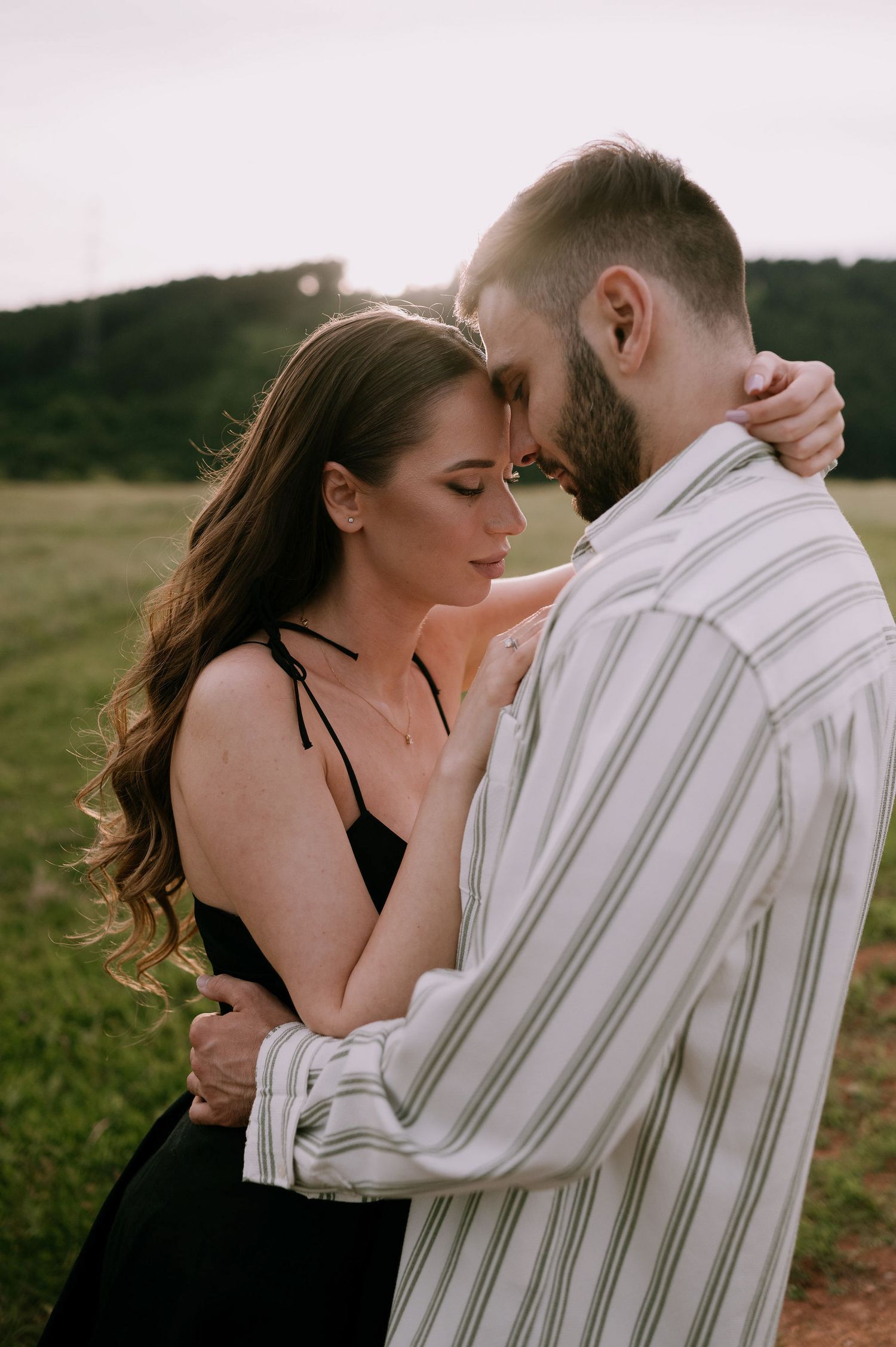 Intimate portrait series showing a couple sharing tender moments against a soft natural backdrop.