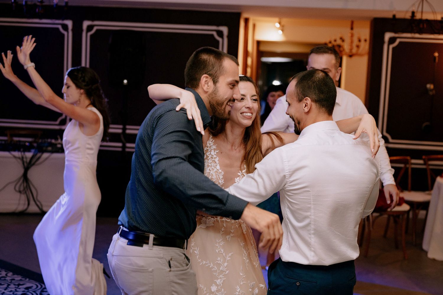 A couple dances together during a wedding reception celebration in an indoor venue.