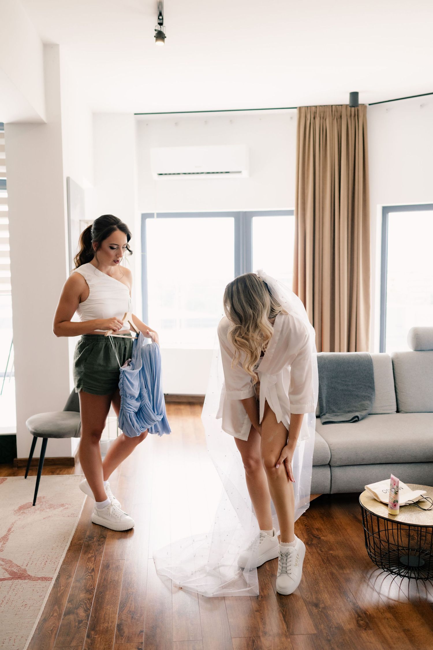 A series of photos showing someone putting on blue denim jeans in a bright modern room with hardwood floors.