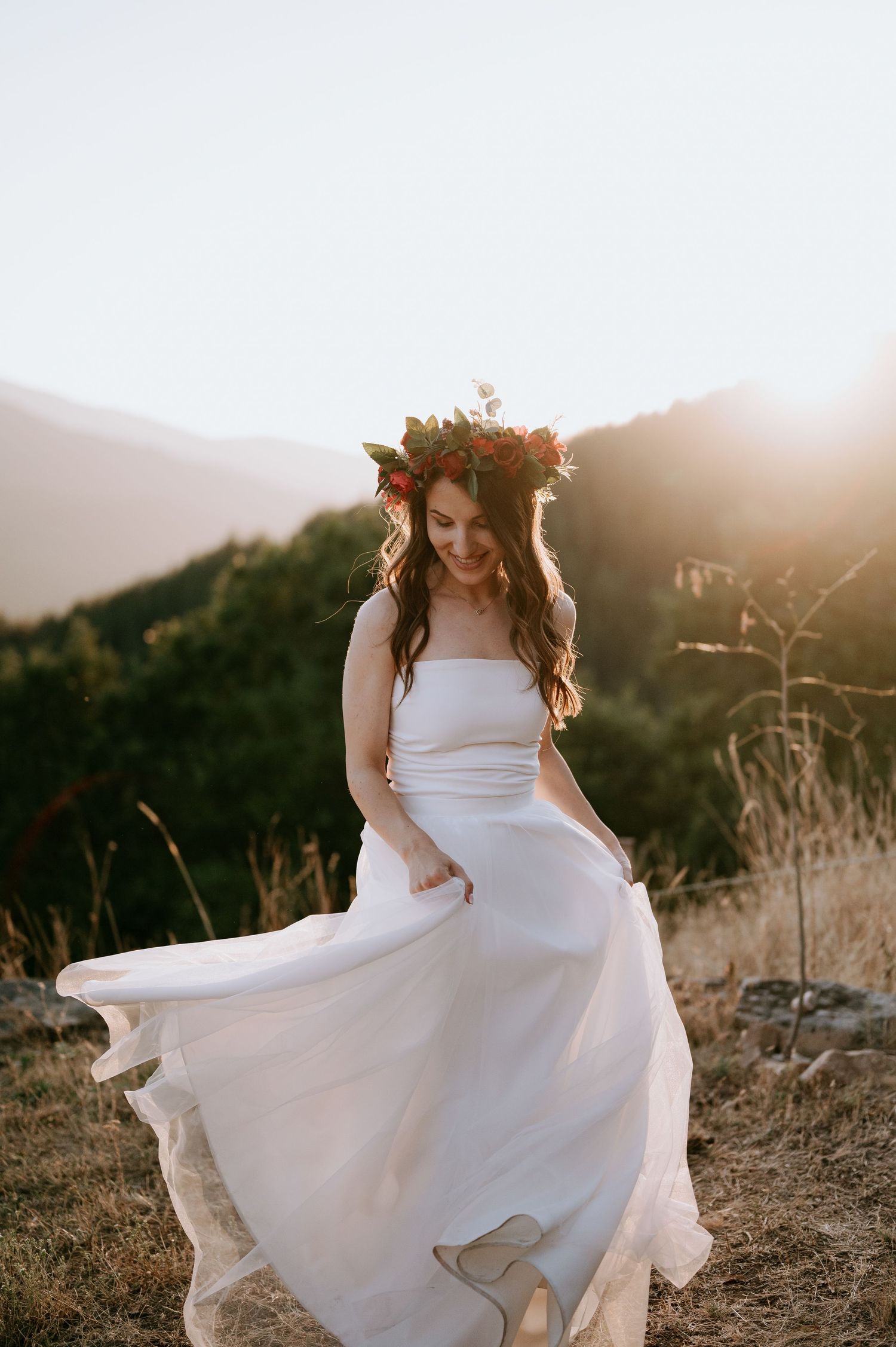 Joyful twirl in a white wedding dress during golden hour in the mountains.