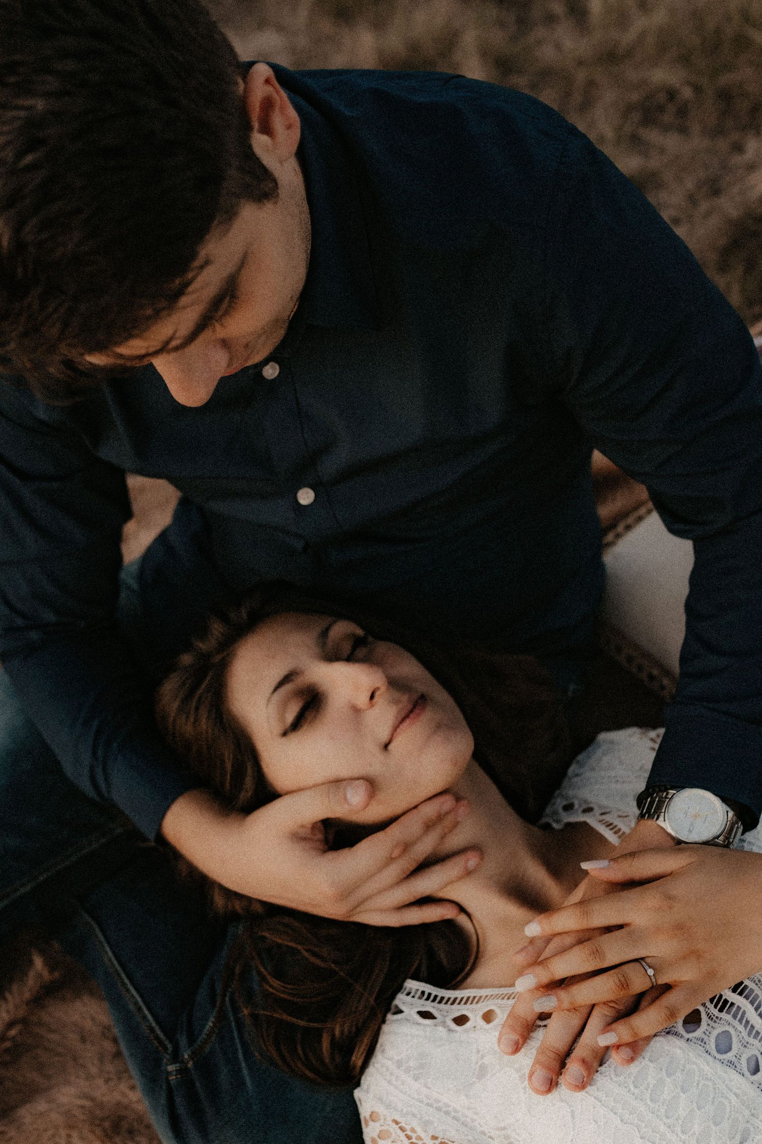 Intimate moment captured during sunset picnic with couple in formal attire.
