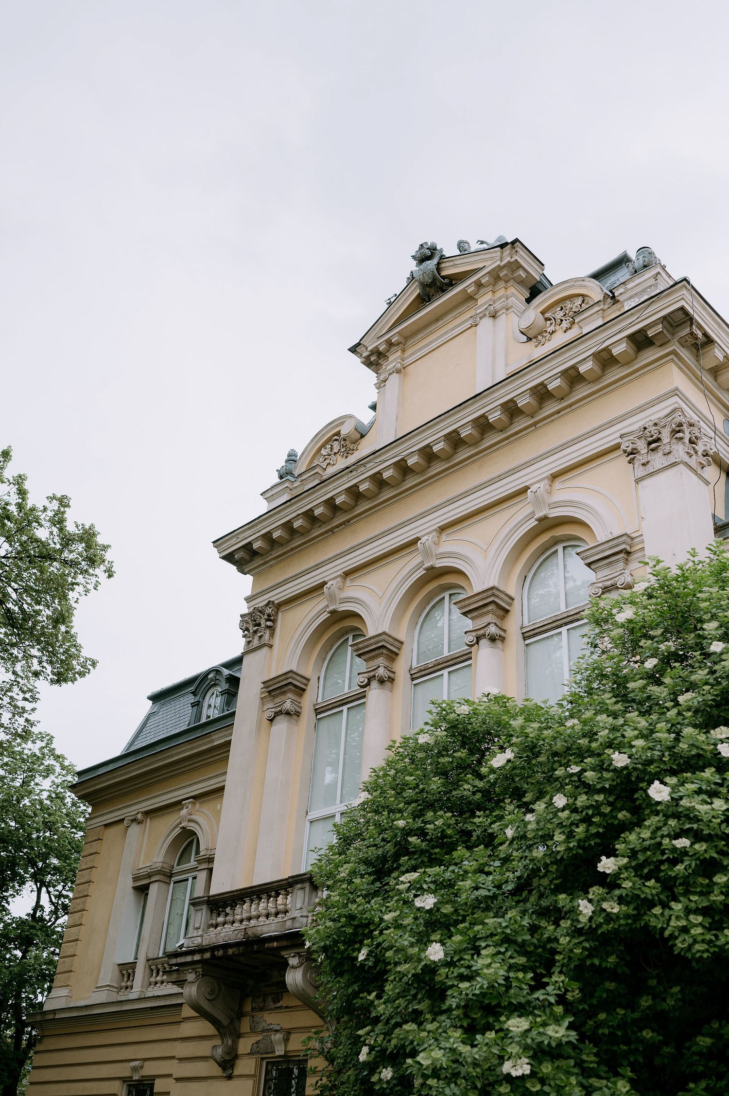 Ornate architectural details of a historic cream-colored building with arched windows and decorative elements.