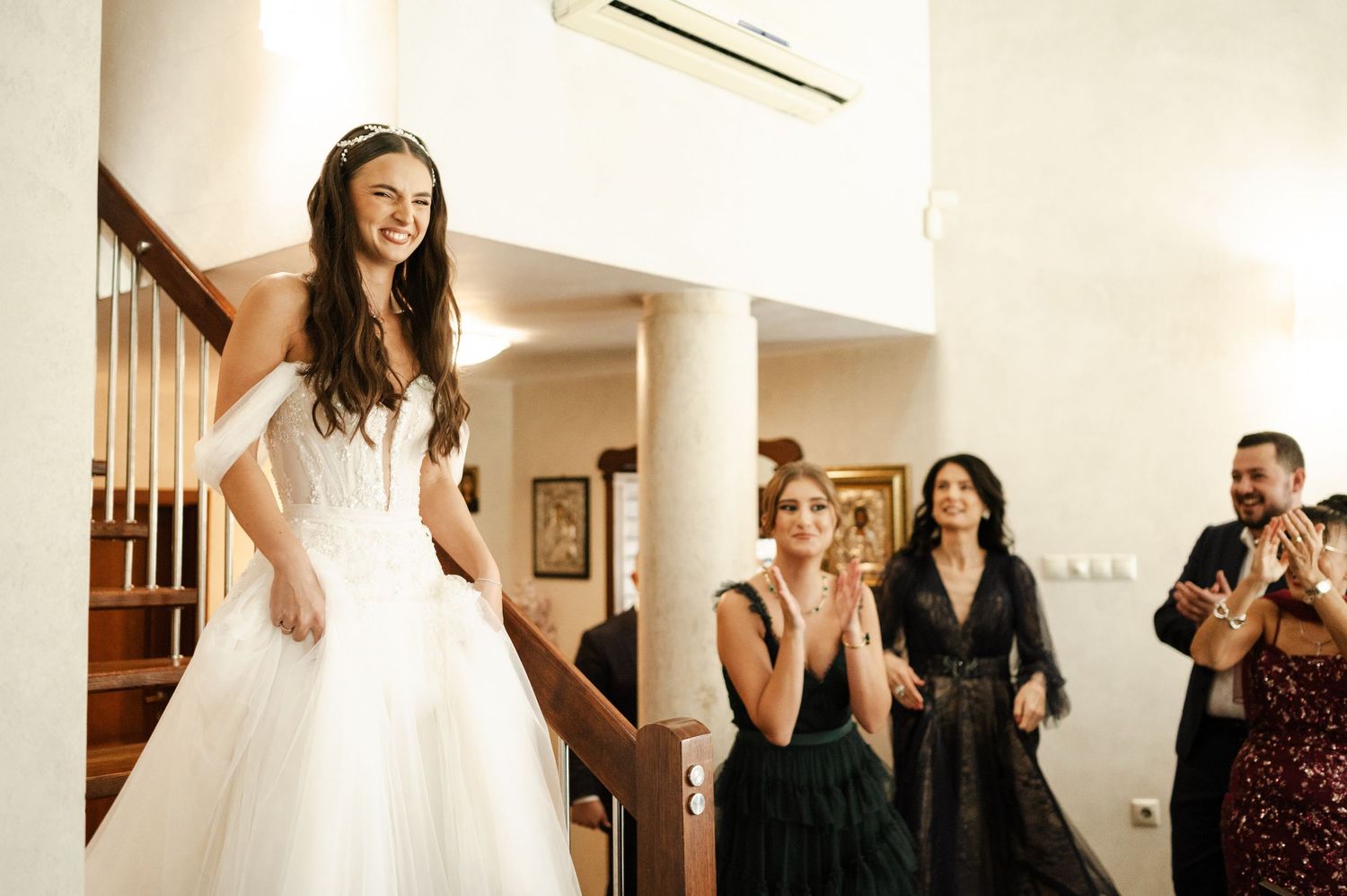 Wedding guests mingle and celebrate in an elegant indoor venue with white walls.