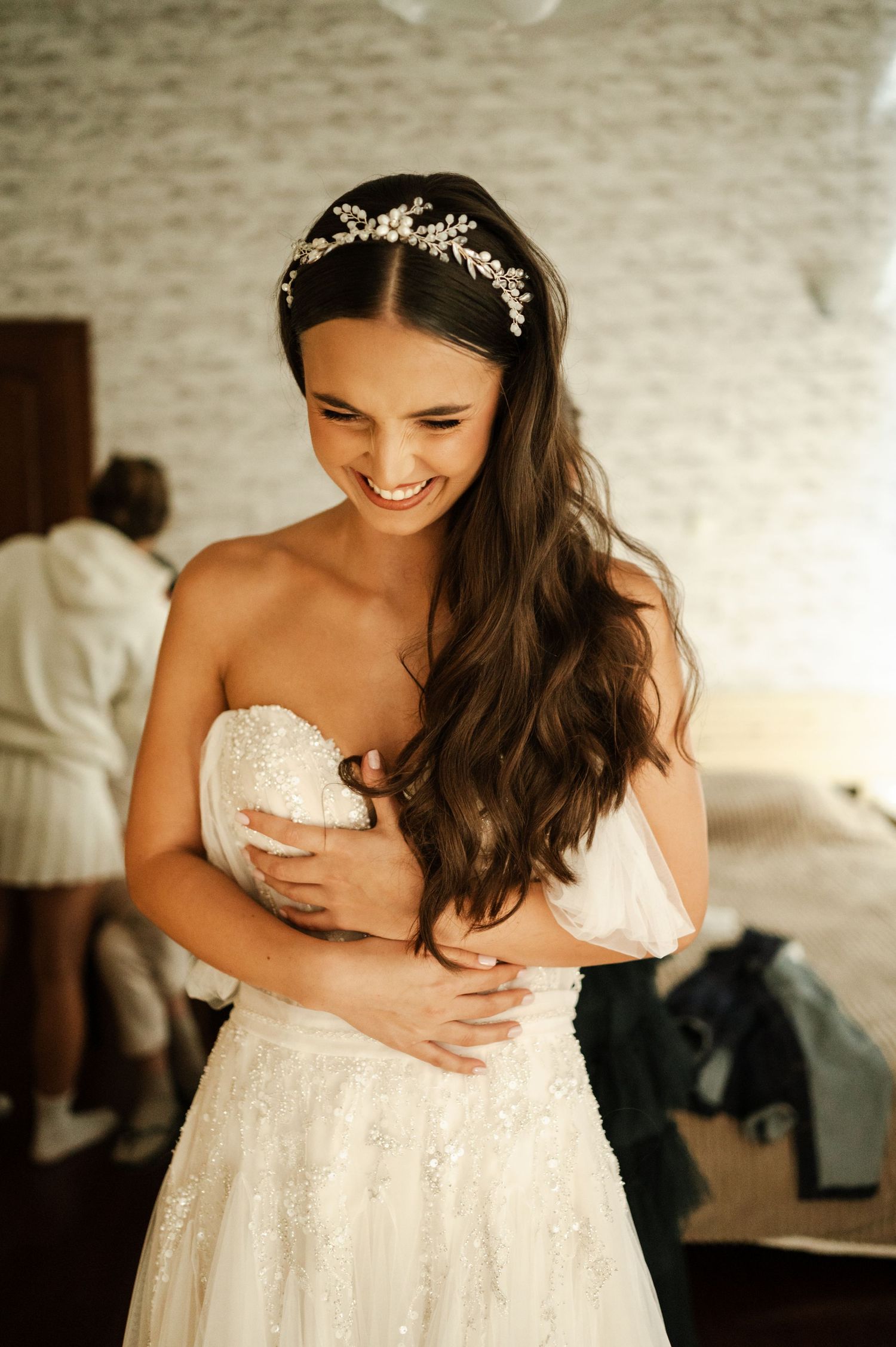 Bride in a strapless lace wedding gown with delicate crystal headpiece.
