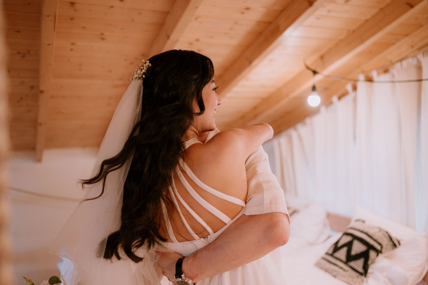 Romantic attic bridal shoot with string lights and natural wood accents.