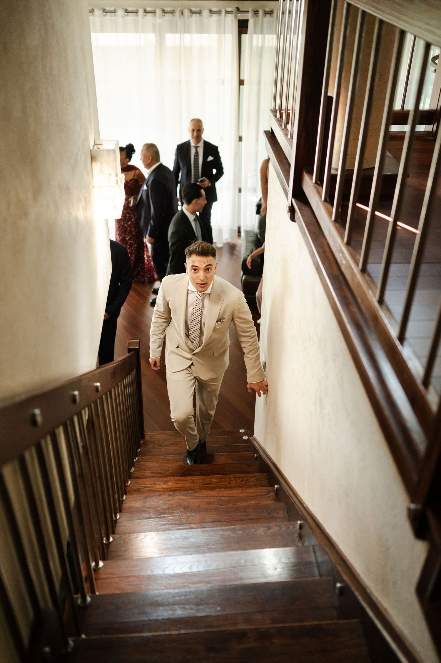 Series of shots showing people walking down a wooden staircase in formal attire.
