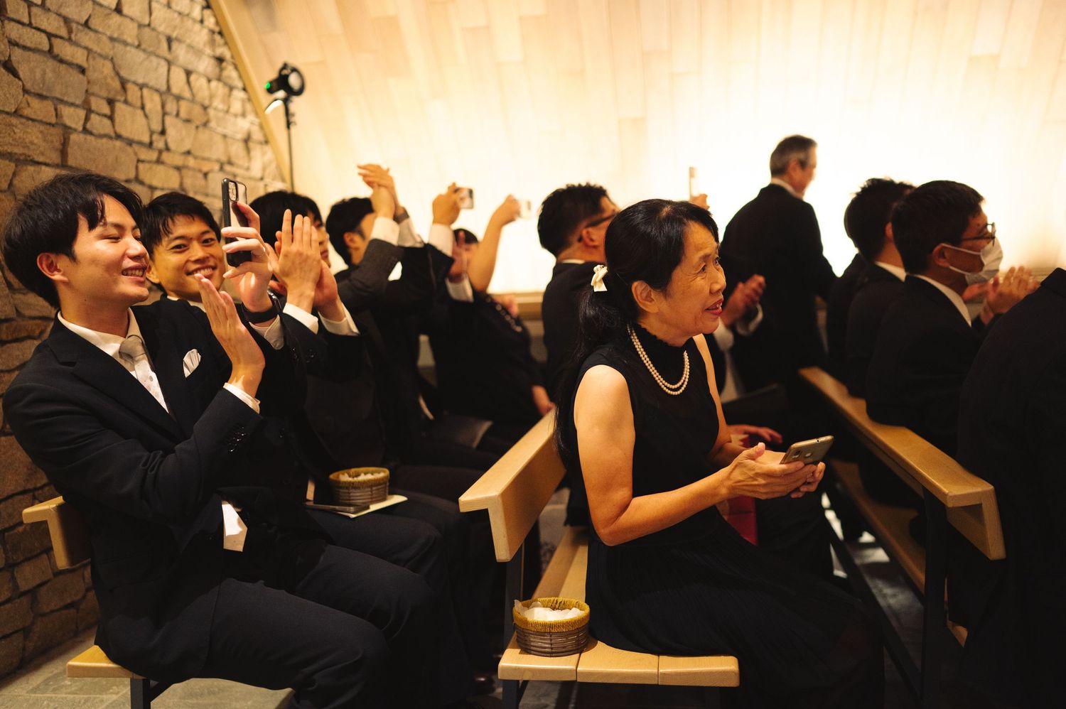 Wedding celebration in an elegant hall with stone walls and warm ambient lighting.