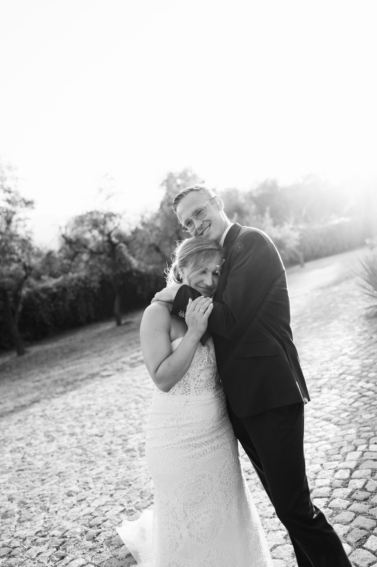 Black and white wedding sequence showing emotional embrace on stone pathway.