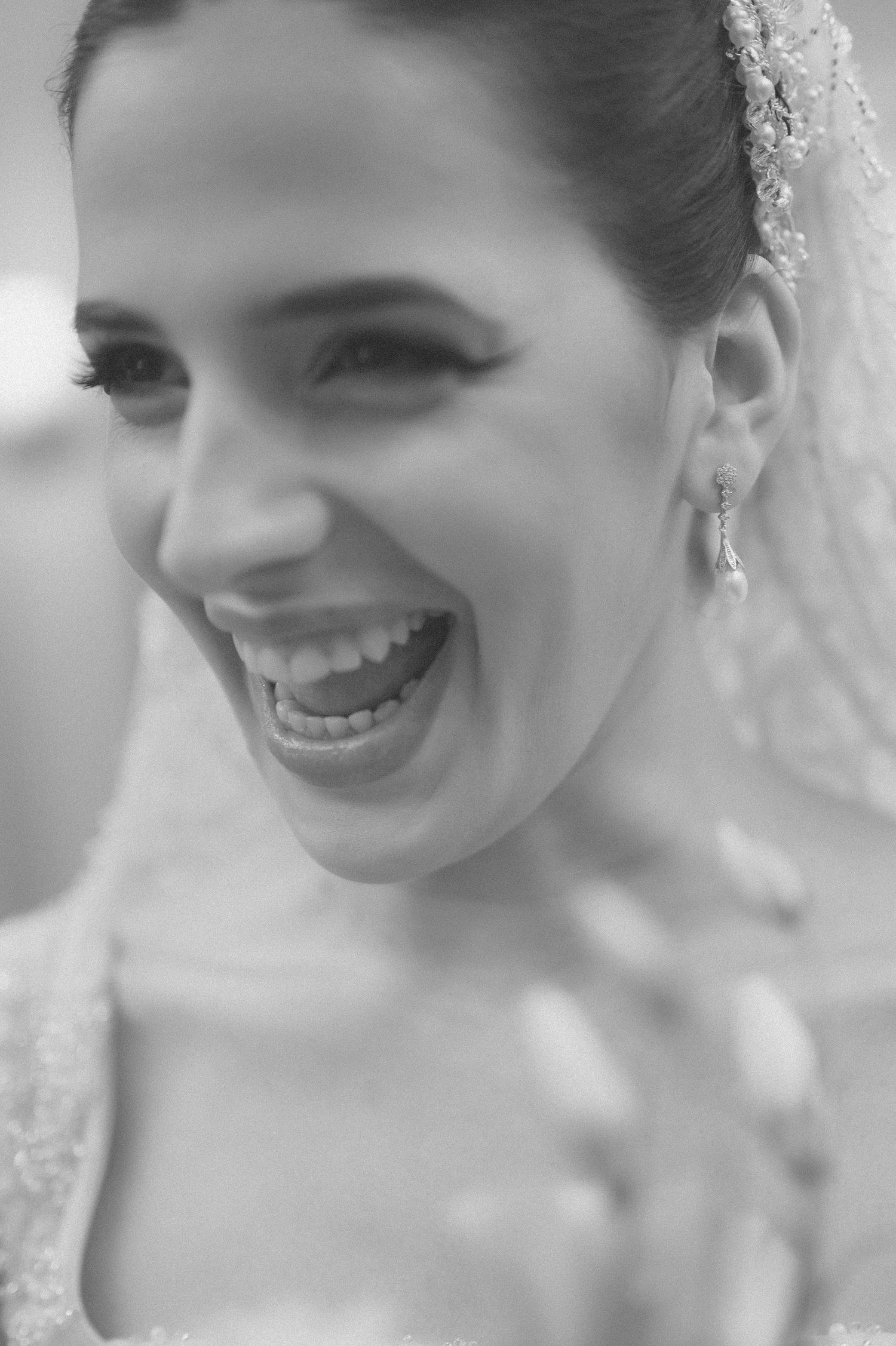 Black and white candid portrait capturing pure joy and laughter on wedding day.