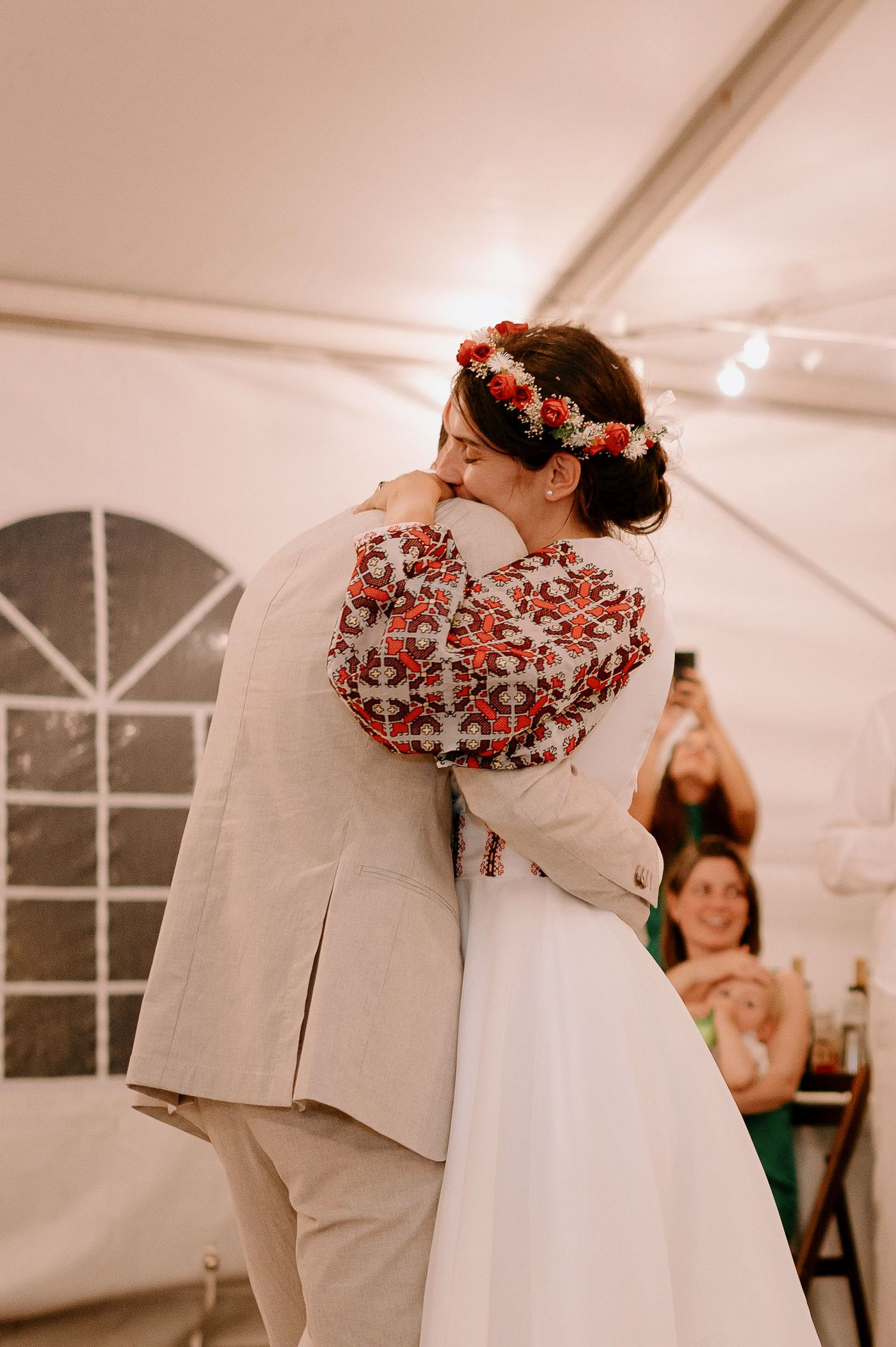 Couple sharing their first dance under romantic string lights at wedding reception.