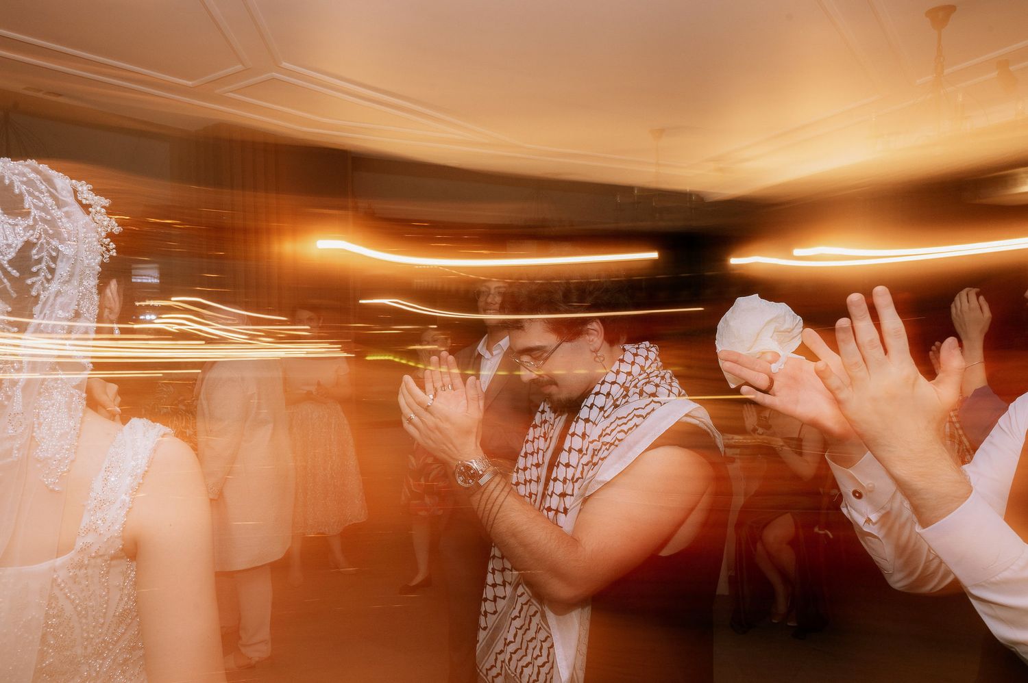 Elegant wedding reception under tent with guests in formal attire on patterned rug.