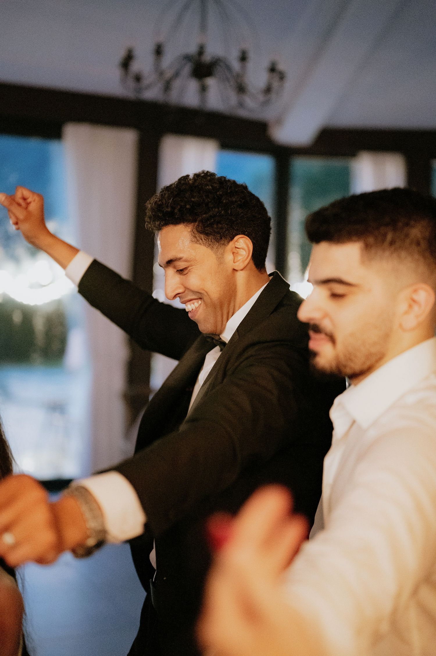 Groomsmen celebrating and dancing together at a wedding reception.