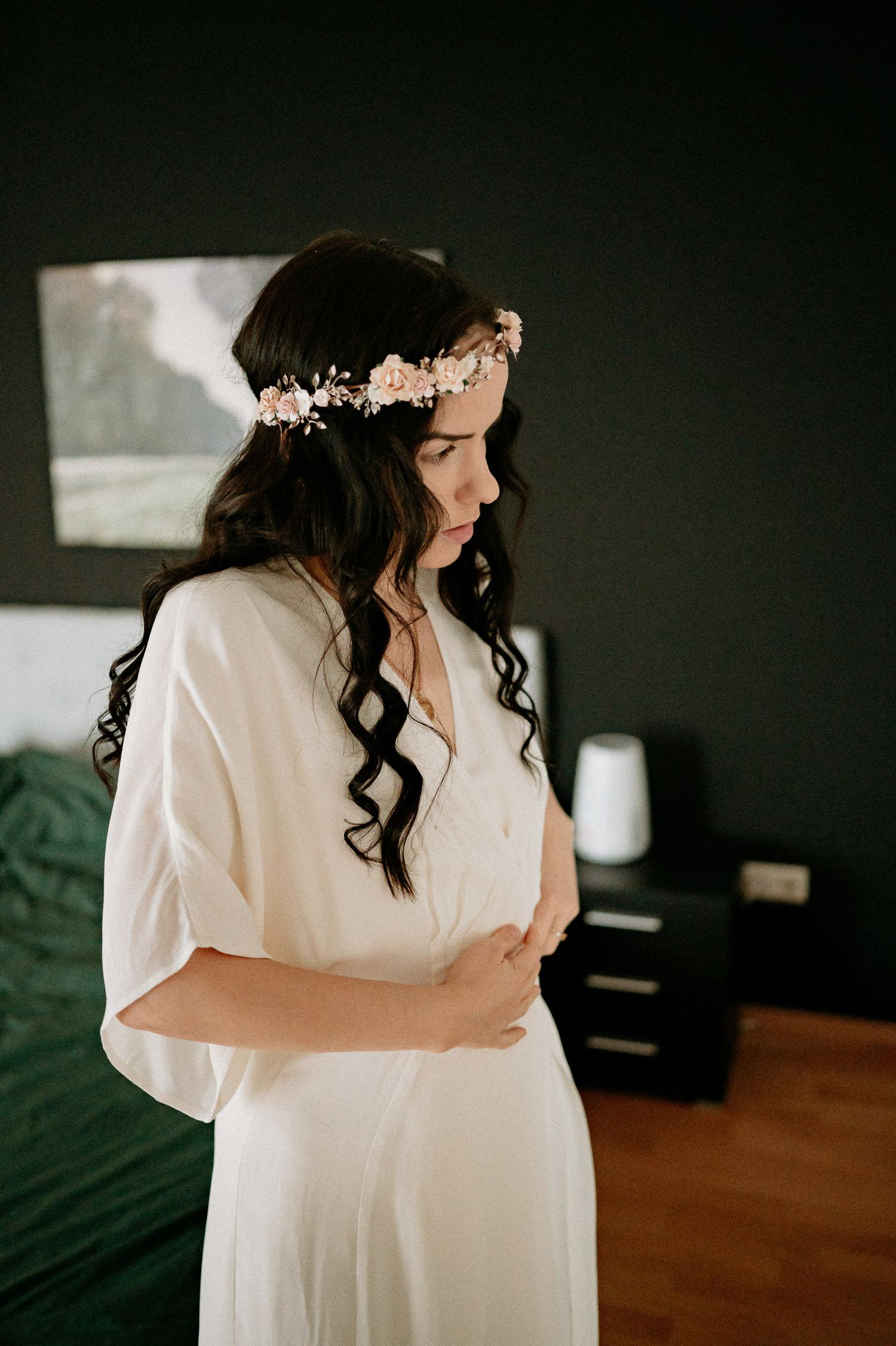Artistic boudoir photography with dark backdrop and flowing white garments.