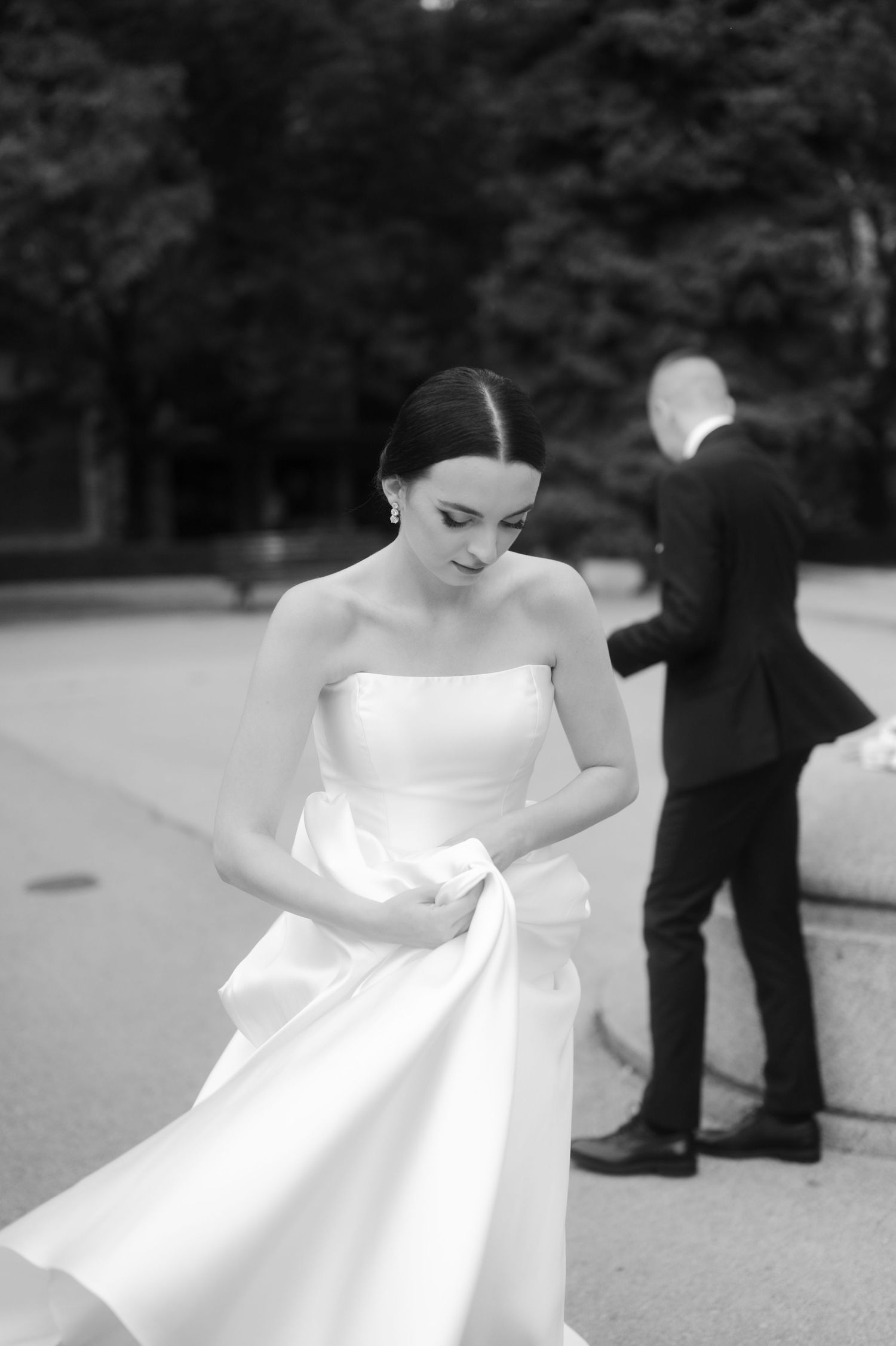 A black and white sequence of a bride in a flowing white dress twirling and dancing outdoors.