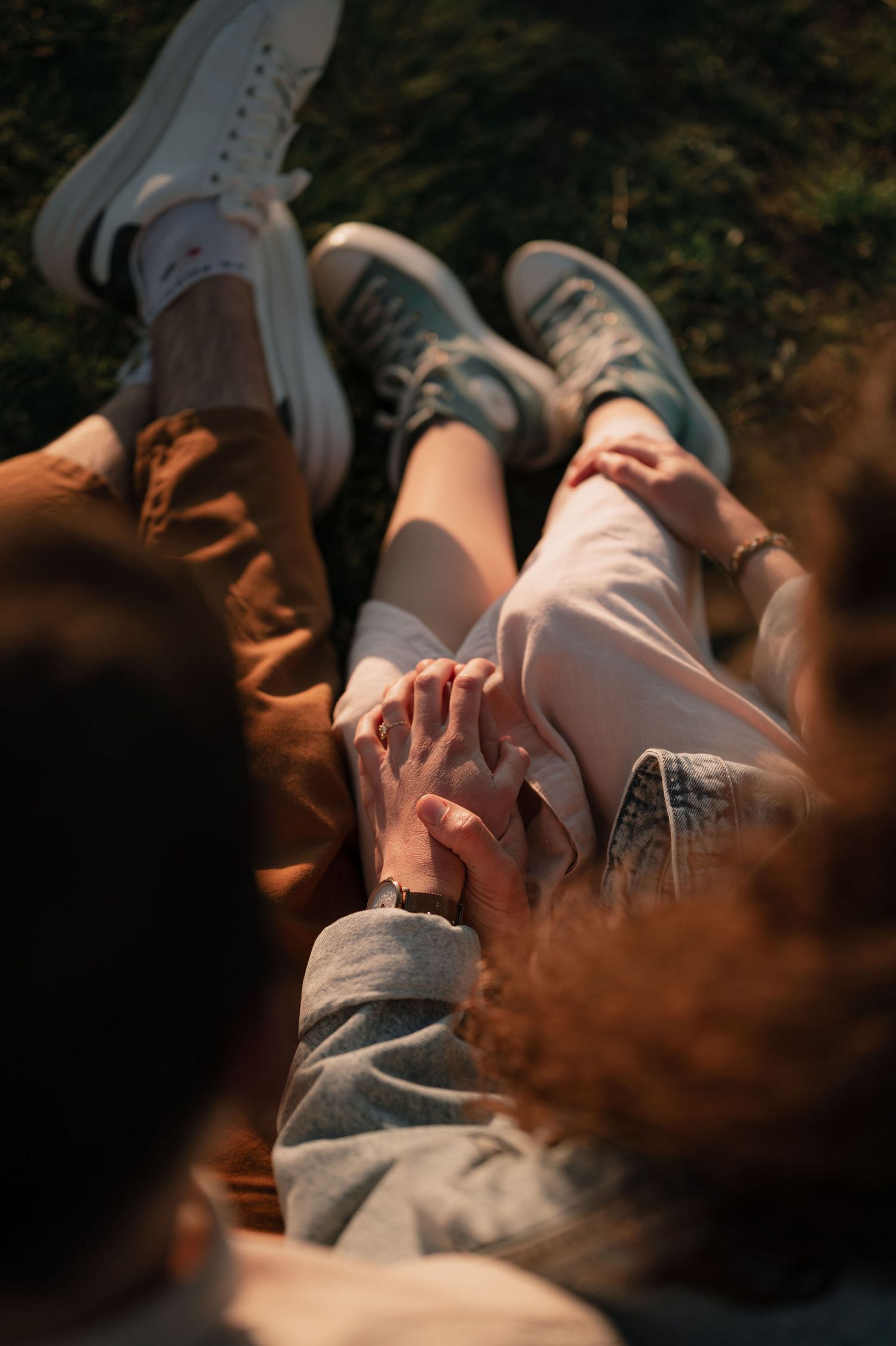 Close-up shot of someone lying down outdoors in casual clothing with sunlight creating dramatic shadows.