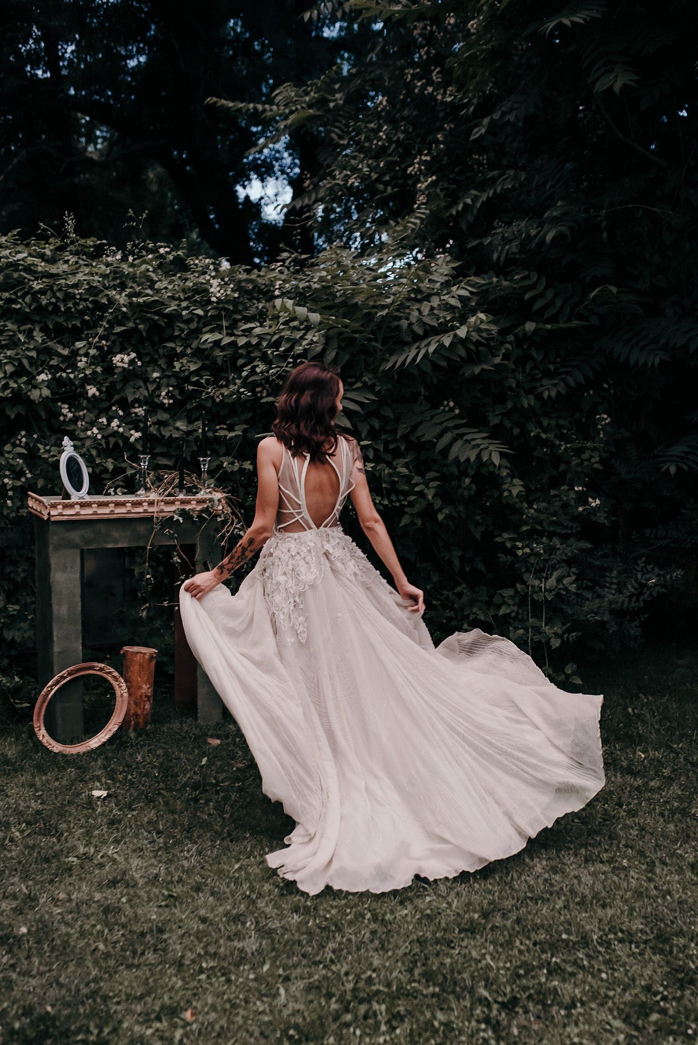 A series of photos showing a flowing white dress twirling gracefully in an outdoor garden setting with trees in the background.