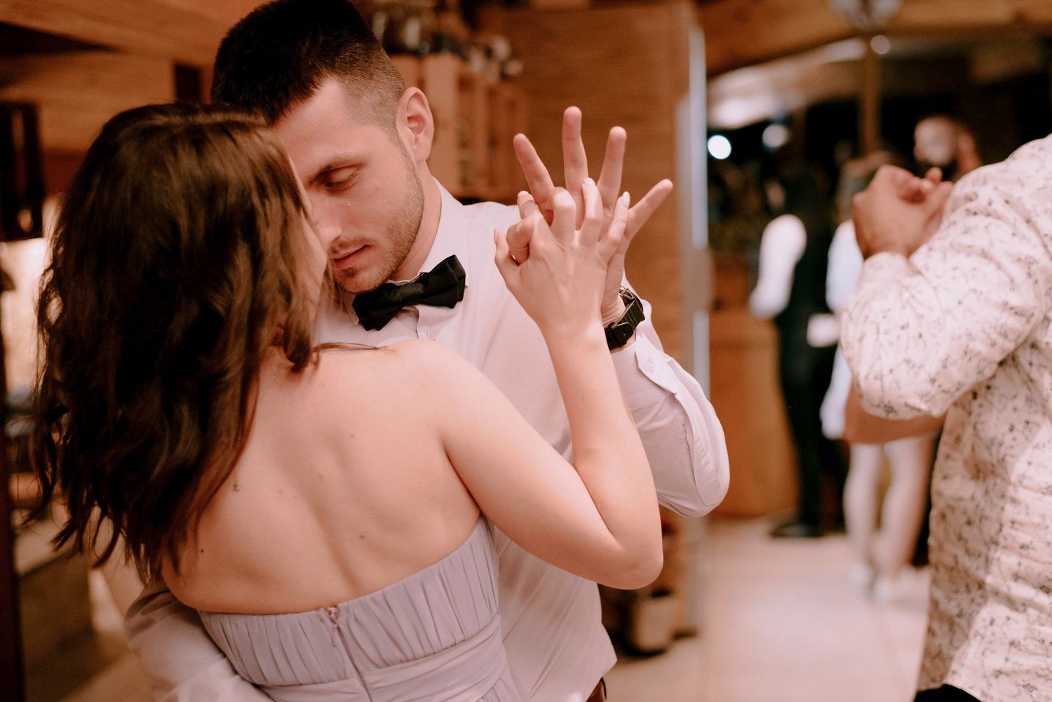 Wedding guests dancing and celebrating on a lively dance floor.
