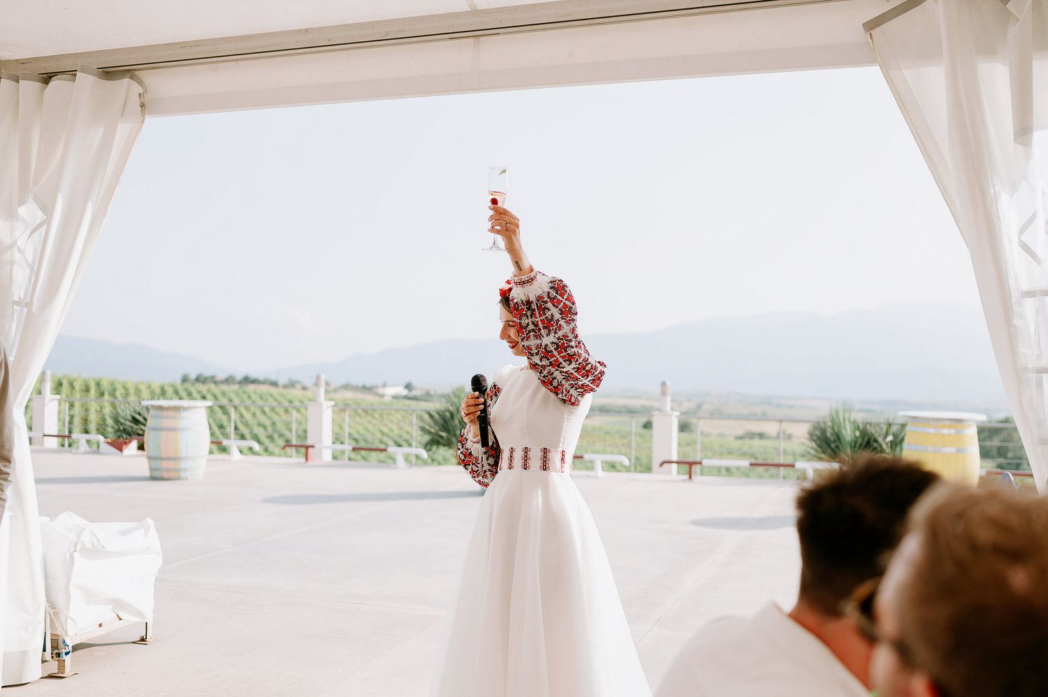 Outdoor wedding reception tent with scenic mountain views in the background.