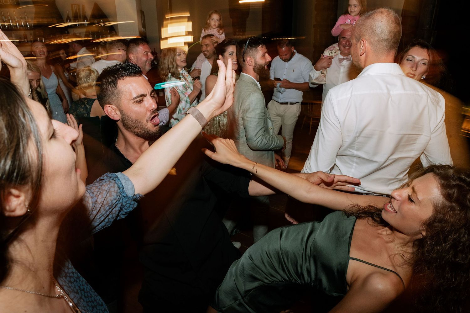 Candid shots of party guests dancing and enjoying themselves at an indoor celebration.