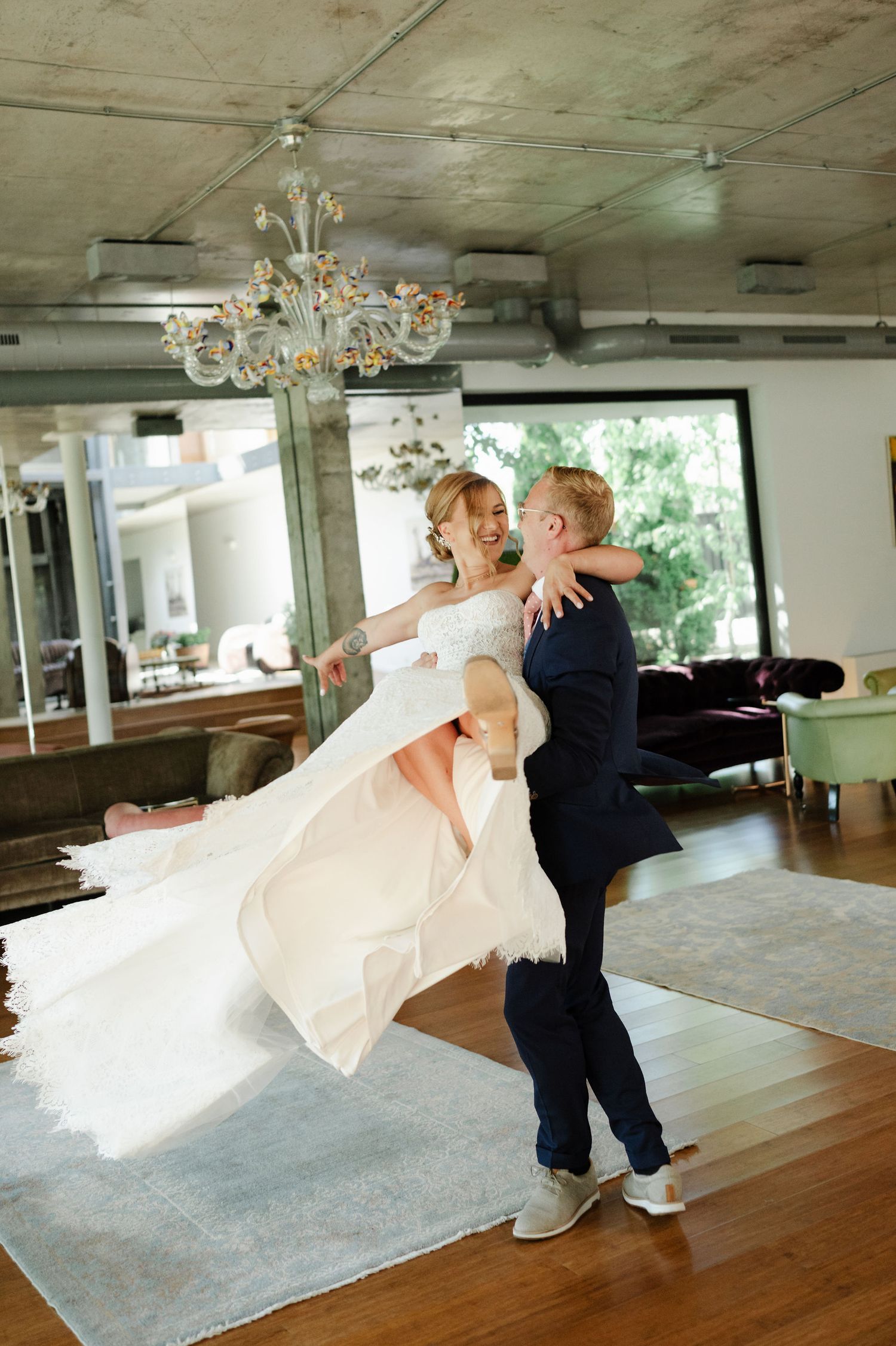 Dynamic shot of bride being lifted and spun during wedding dance performance.