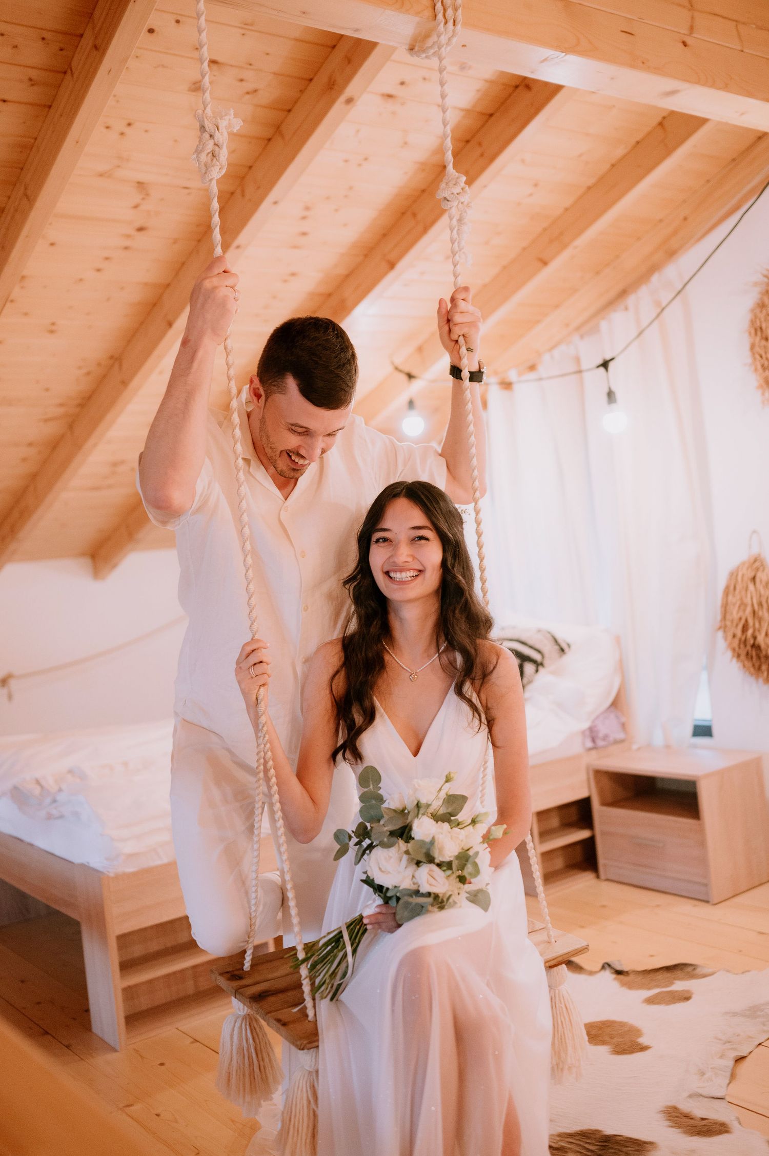 Romantic bridal portraits in a rustic wooden room with natural lighting and white decor.