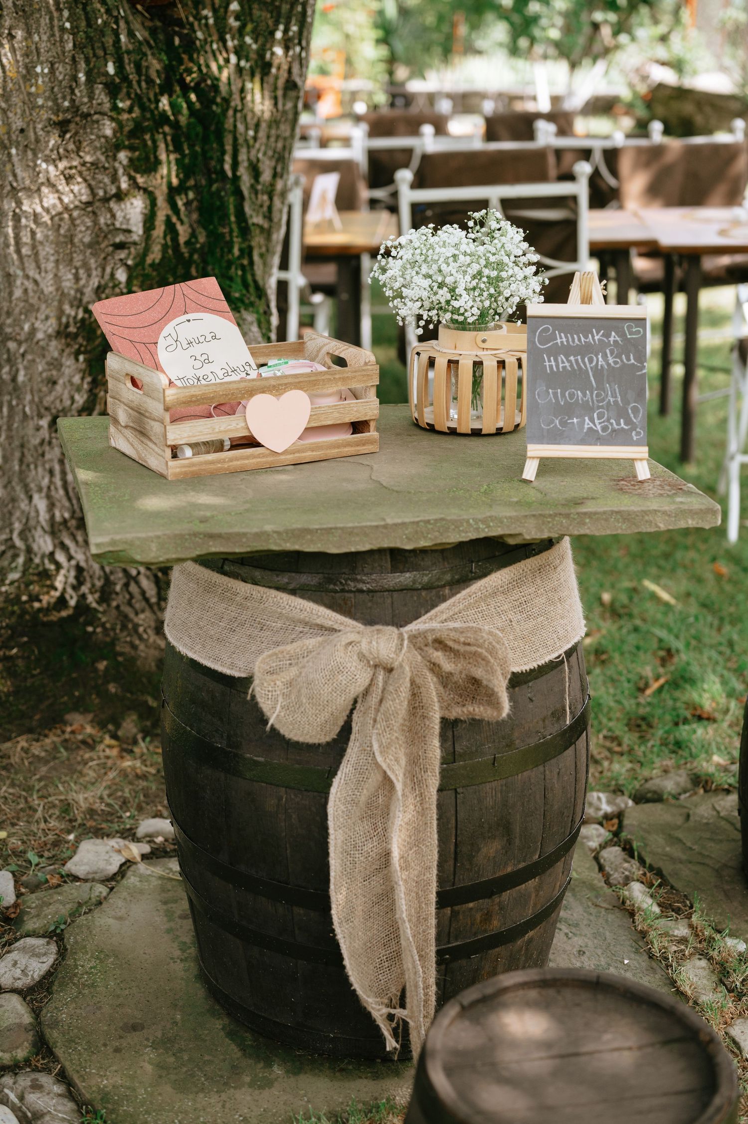 Rustic wedding decor featuring wooden barrels, burlap bows, and baby's breath flowers.