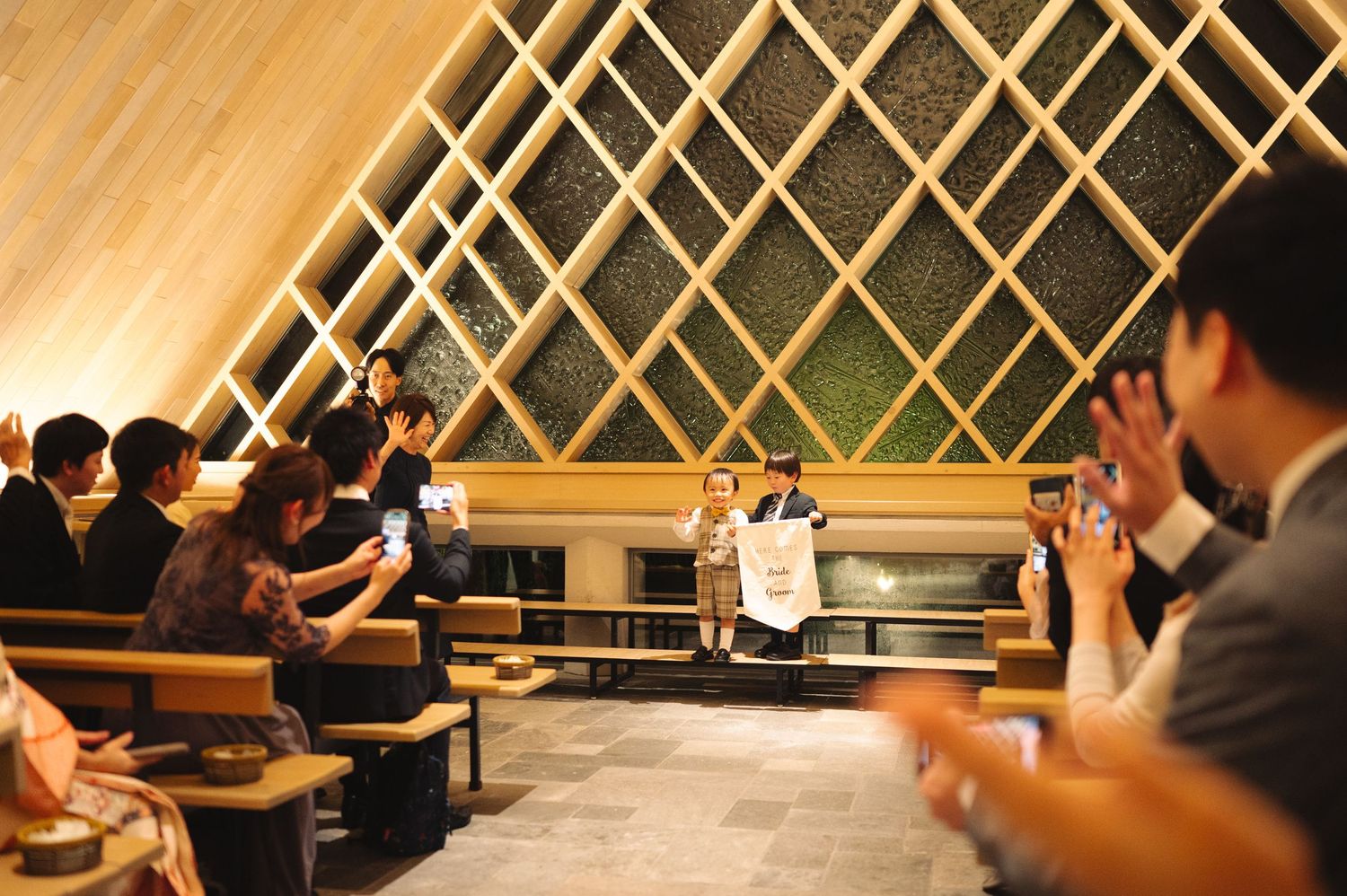 Modern venue with geometric lattice ceiling design and warm ambient lighting during an event.