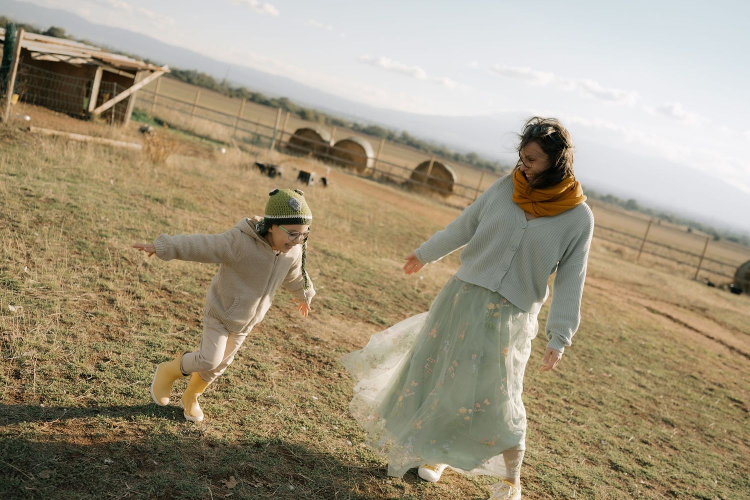 A series of dreamy outdoor photos showing someone in a flowing white dress twirling and dancing in a golden field at sunset.