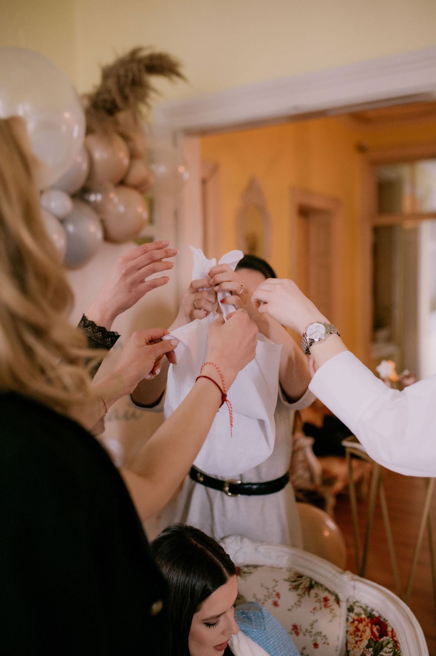A bride and mother share an emotional moment during wedding preparations in a warmly lit room.