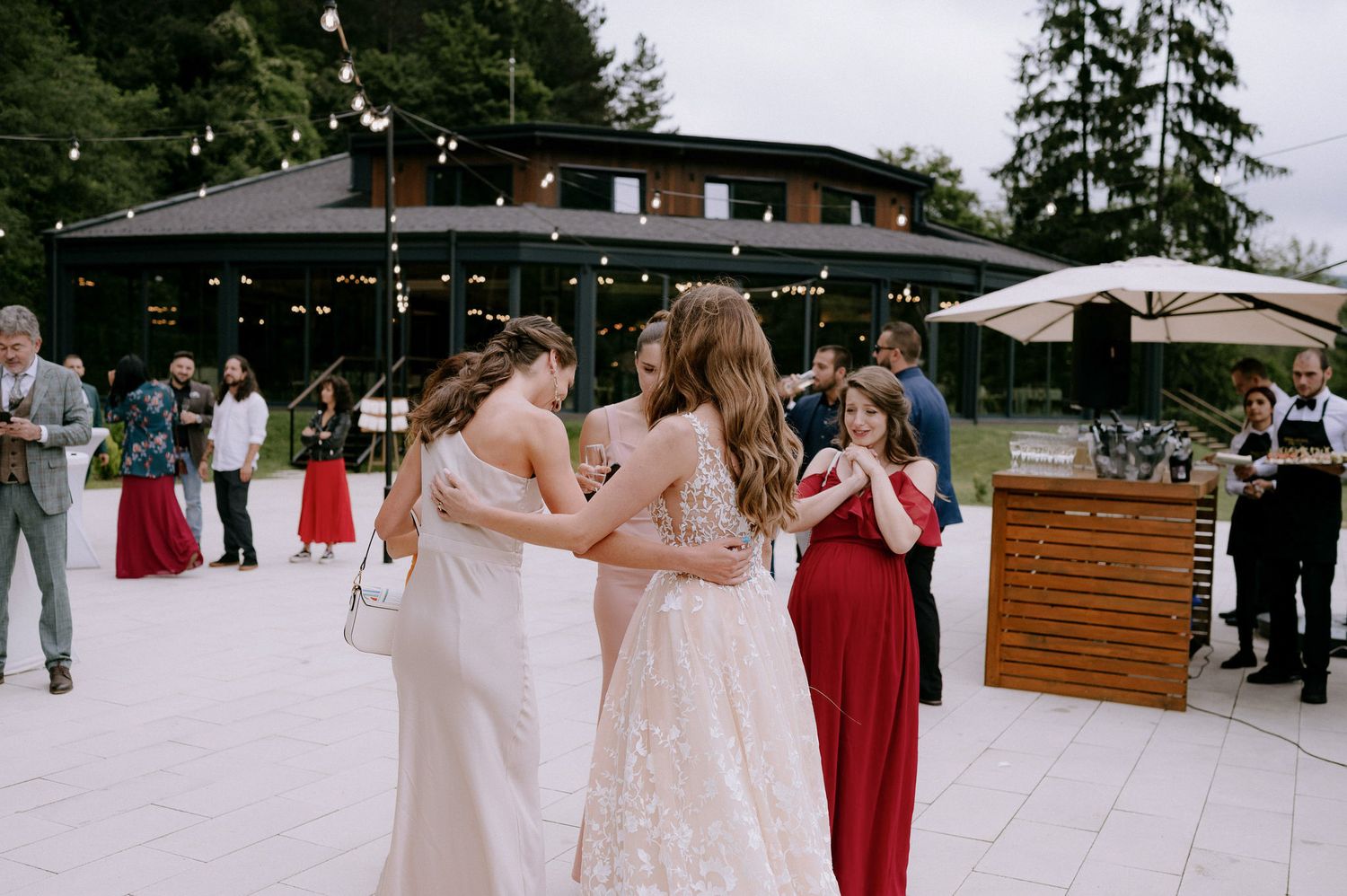 Wedding guests mingle and dance on an outdoor patio during an elegant reception celebration.