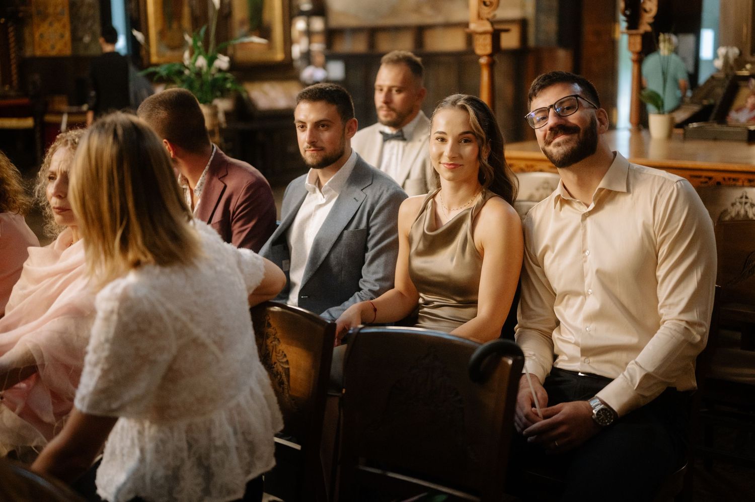 A group of people sitting together at a dimly lit restaurant bar having an evening conversation.