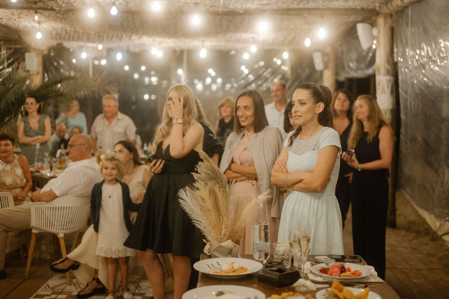 A series of candid moments at a wedding reception showing guests mingling and dancing under warm lighting.