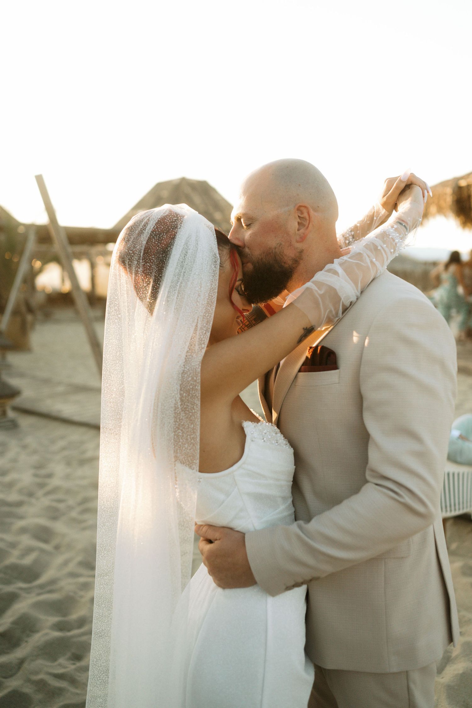 A romantic beach wedding sequence shows a couple sharing intimate kisses at sunset with a flowing white veil.