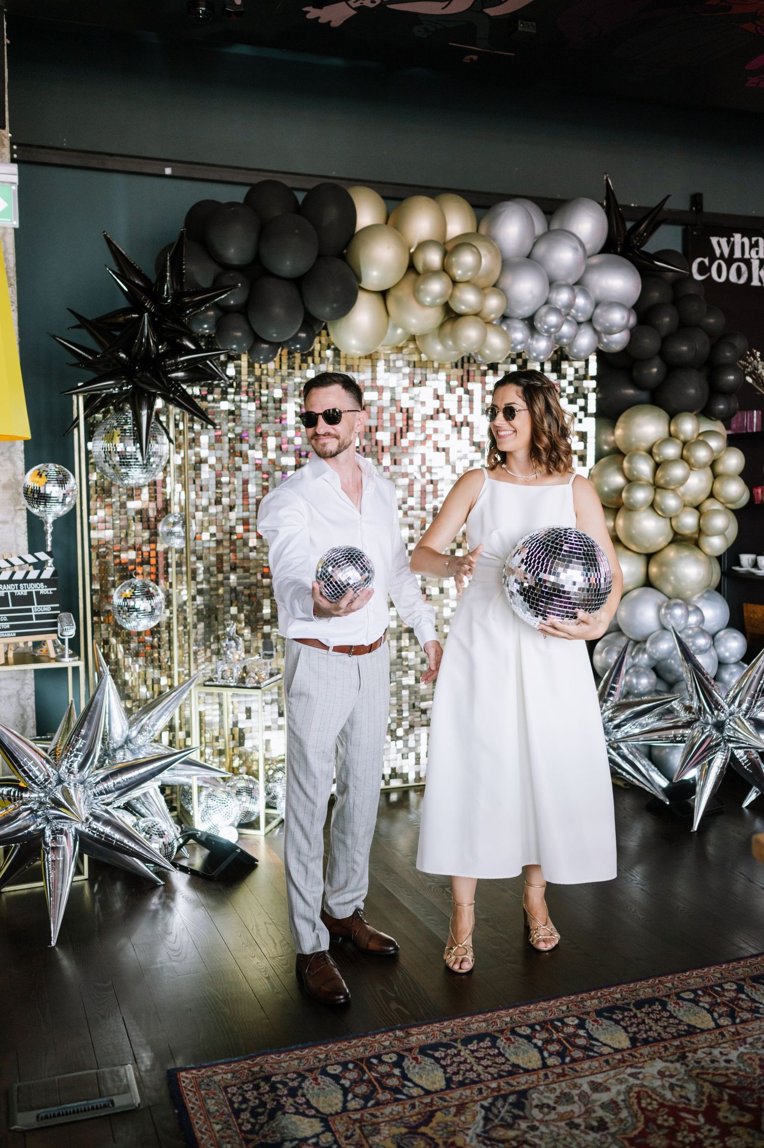 Celebratory event decor with silver star balloons and gold balloon garlands creating an elegant party backdrop.