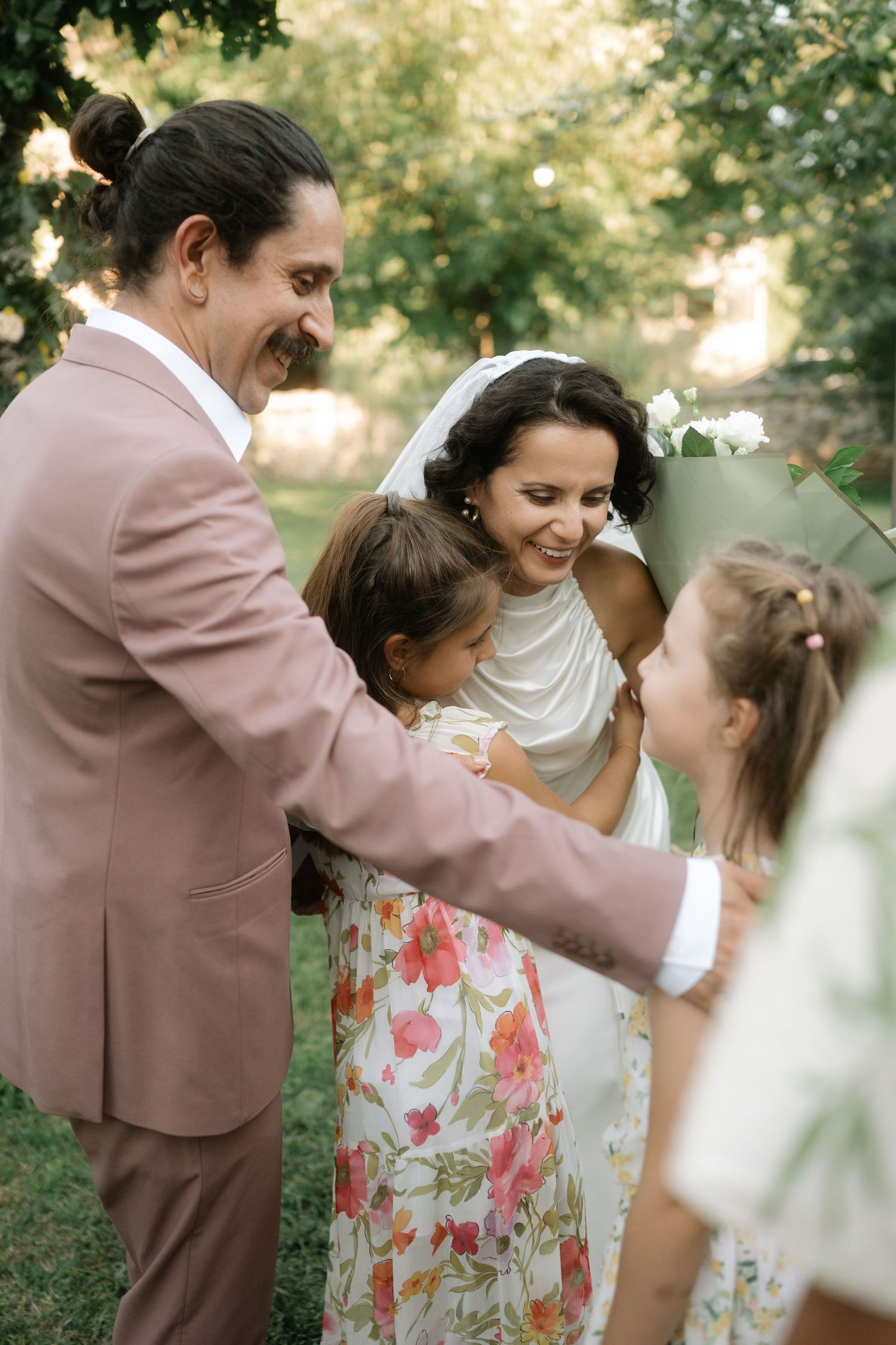 A joyful sequence of candid moments captured in a garden setting shows dancing and laughter in soft natural light.