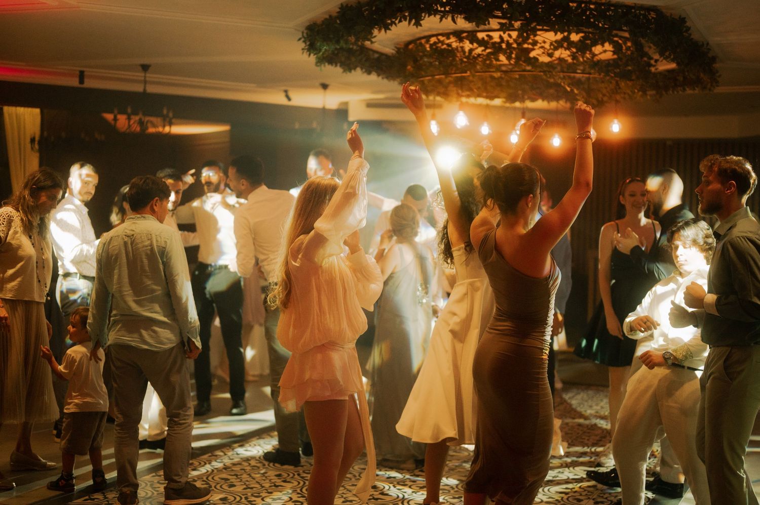 Couples dancing together at a dimly lit wedding reception with sparklers creating a magical atmosphere.