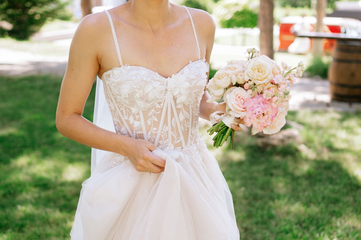Romantic outdoor wedding venue with wooden chairs arranged beneath tall pine trees.