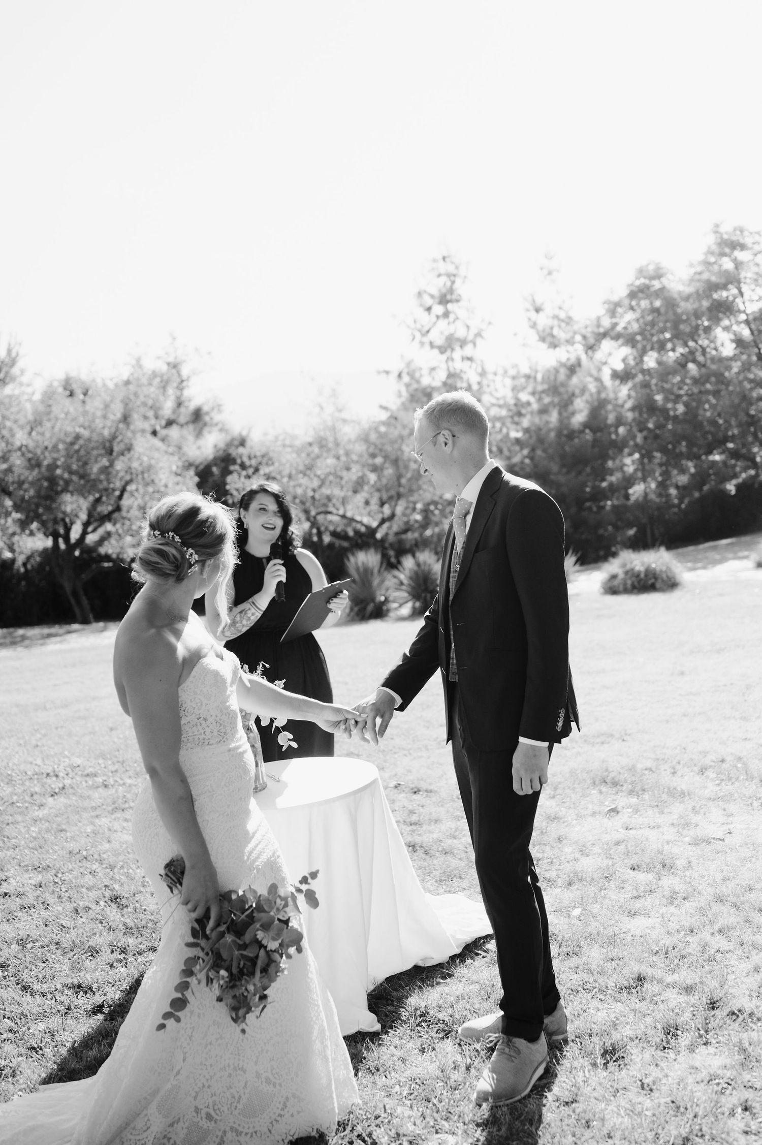 Black and white photo of wedding party interacting during outdoor photo session.