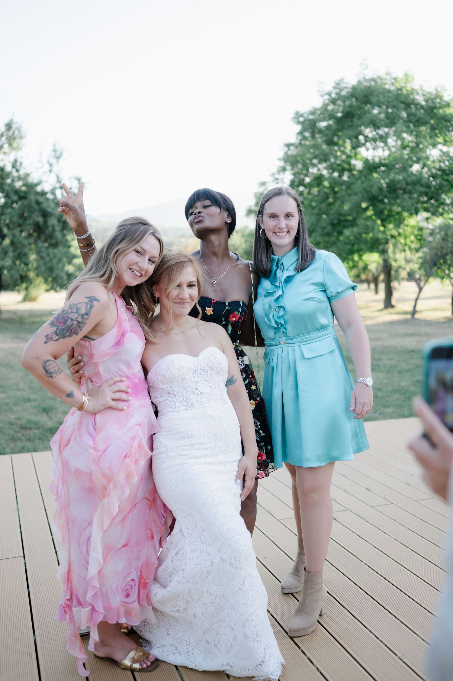 Candid moment of wedding party laughing on rustic deck.