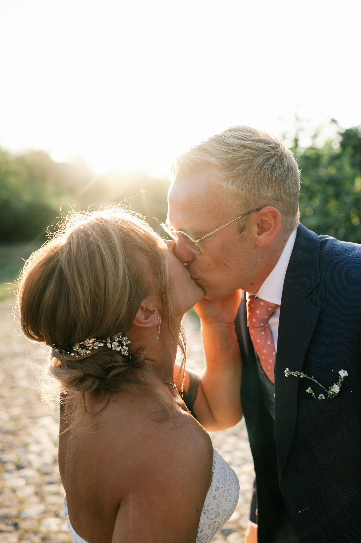 Golden hour wedding portraits capturing romantic kisses on a stone path.