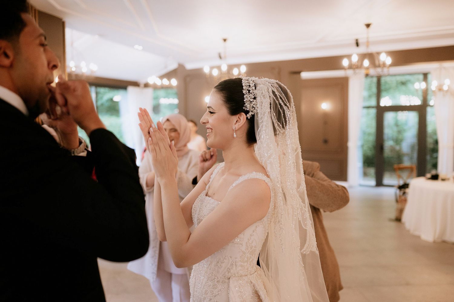 Guests gather for a celebration in a bright indoor venue with modern lighting fixtures.