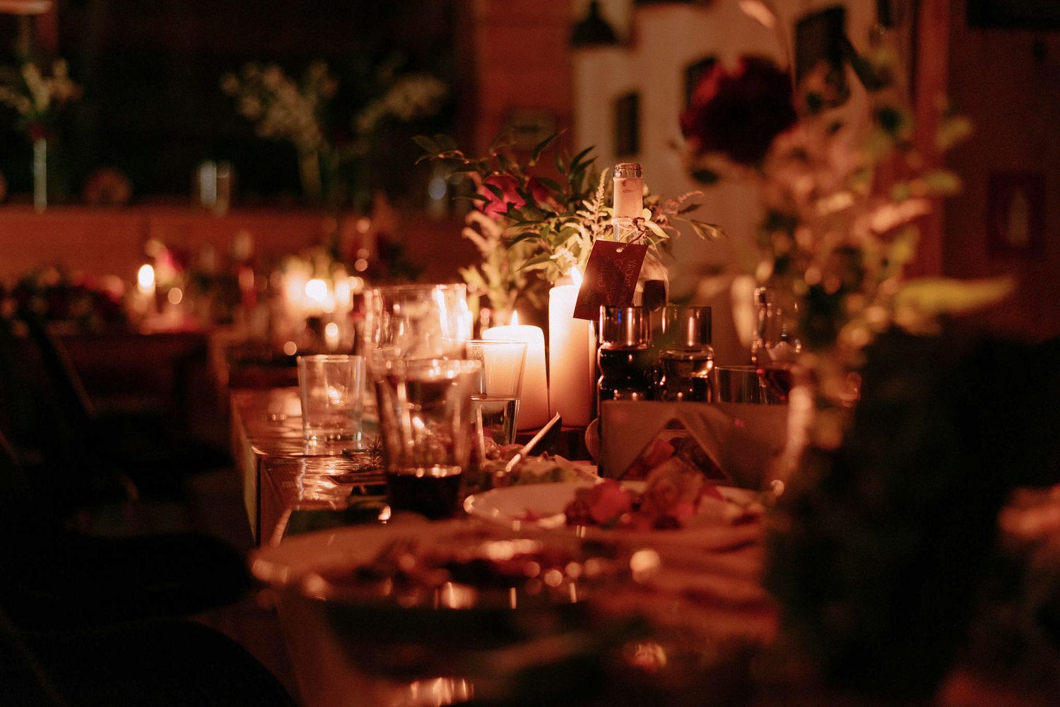 Romantic candlelit wedding reception tables with elegant place settings.