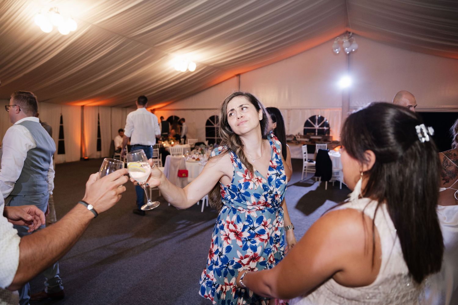 Guests dancing and celebrating together at a wedding reception under warm lighting in an indoor venue.