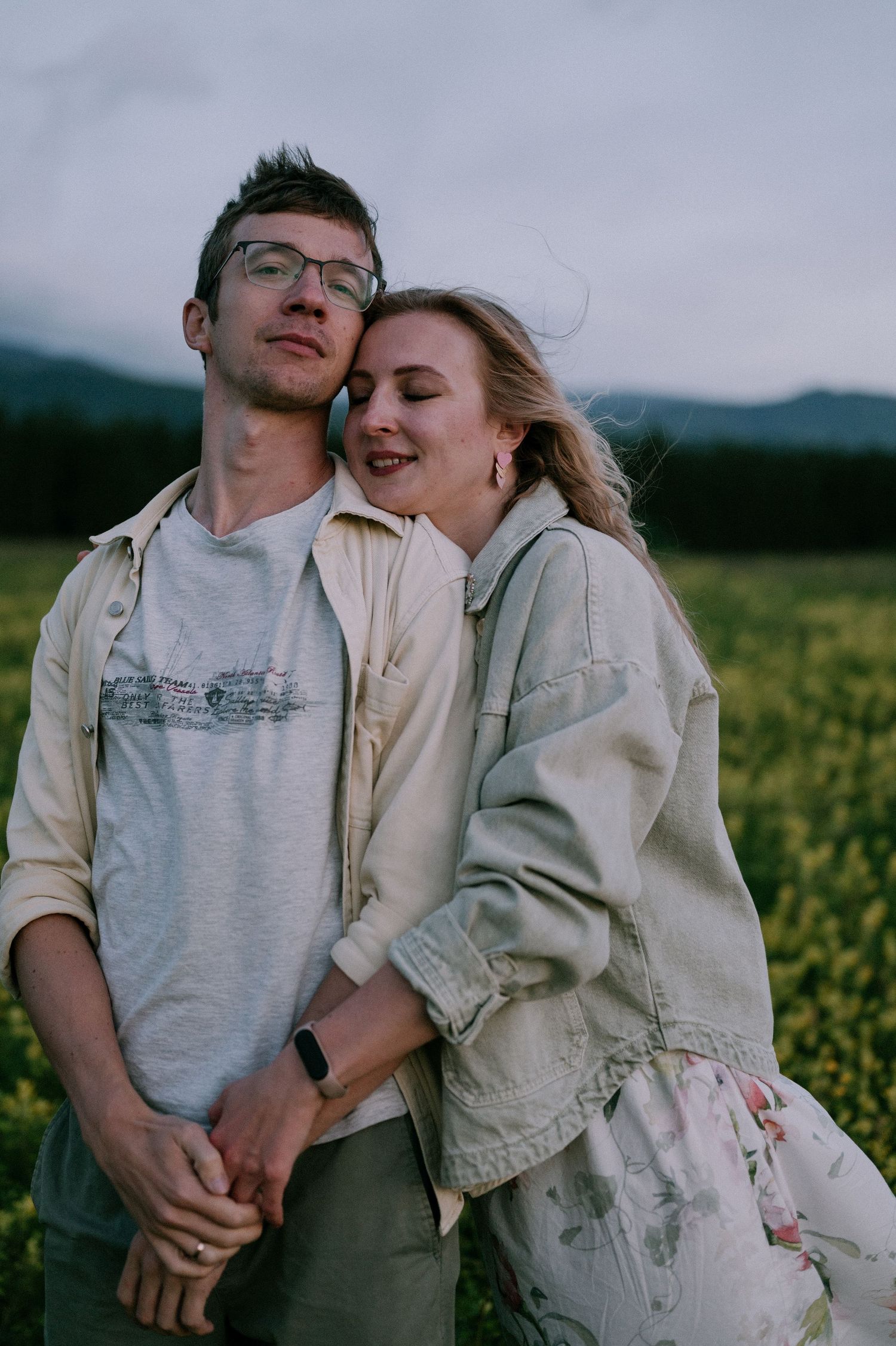 A tender embrace captured in a blooming yellow flower field during golden hour.