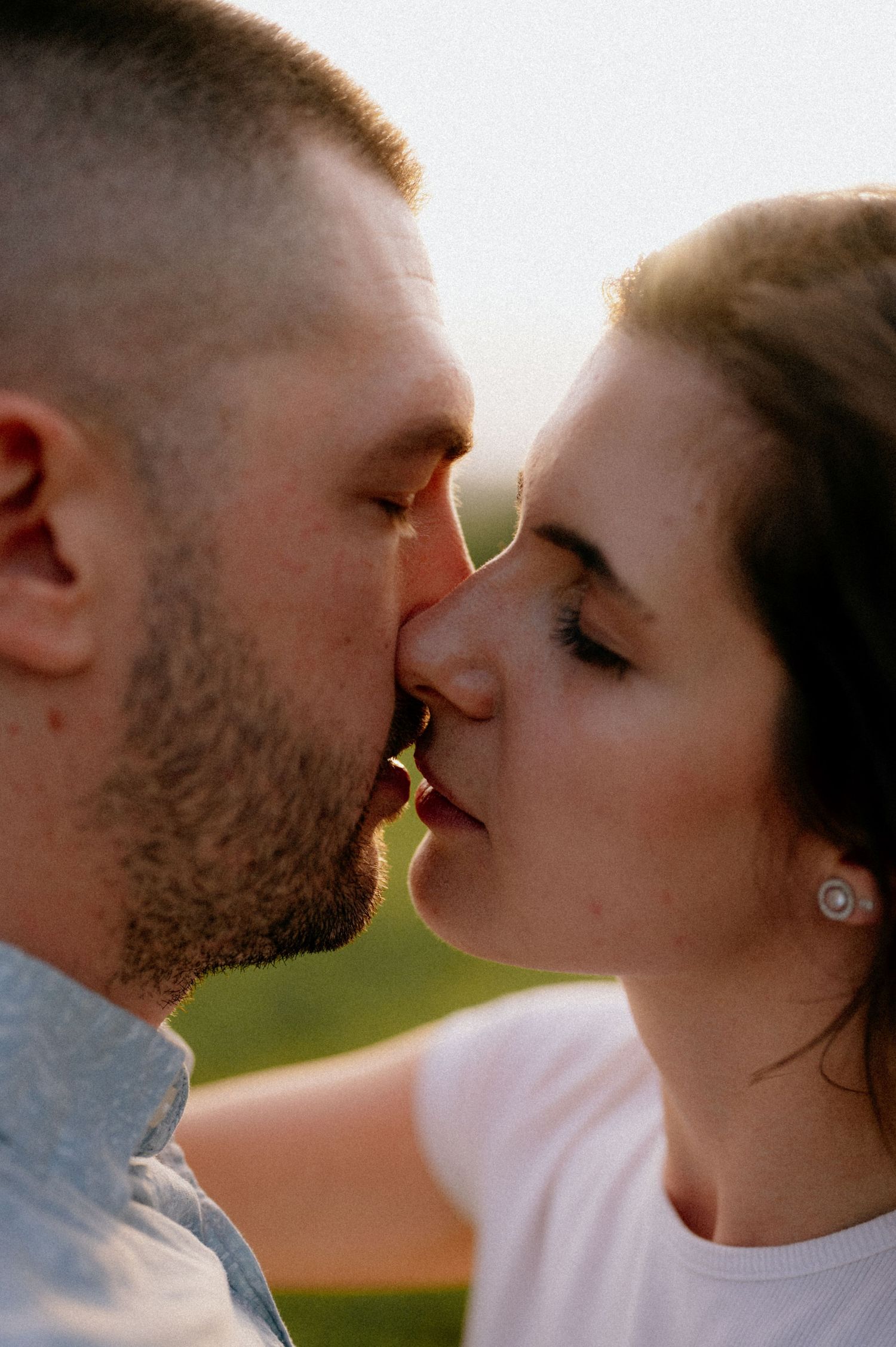 Close-up of intimate moment between couple during outdoor photoshoot.