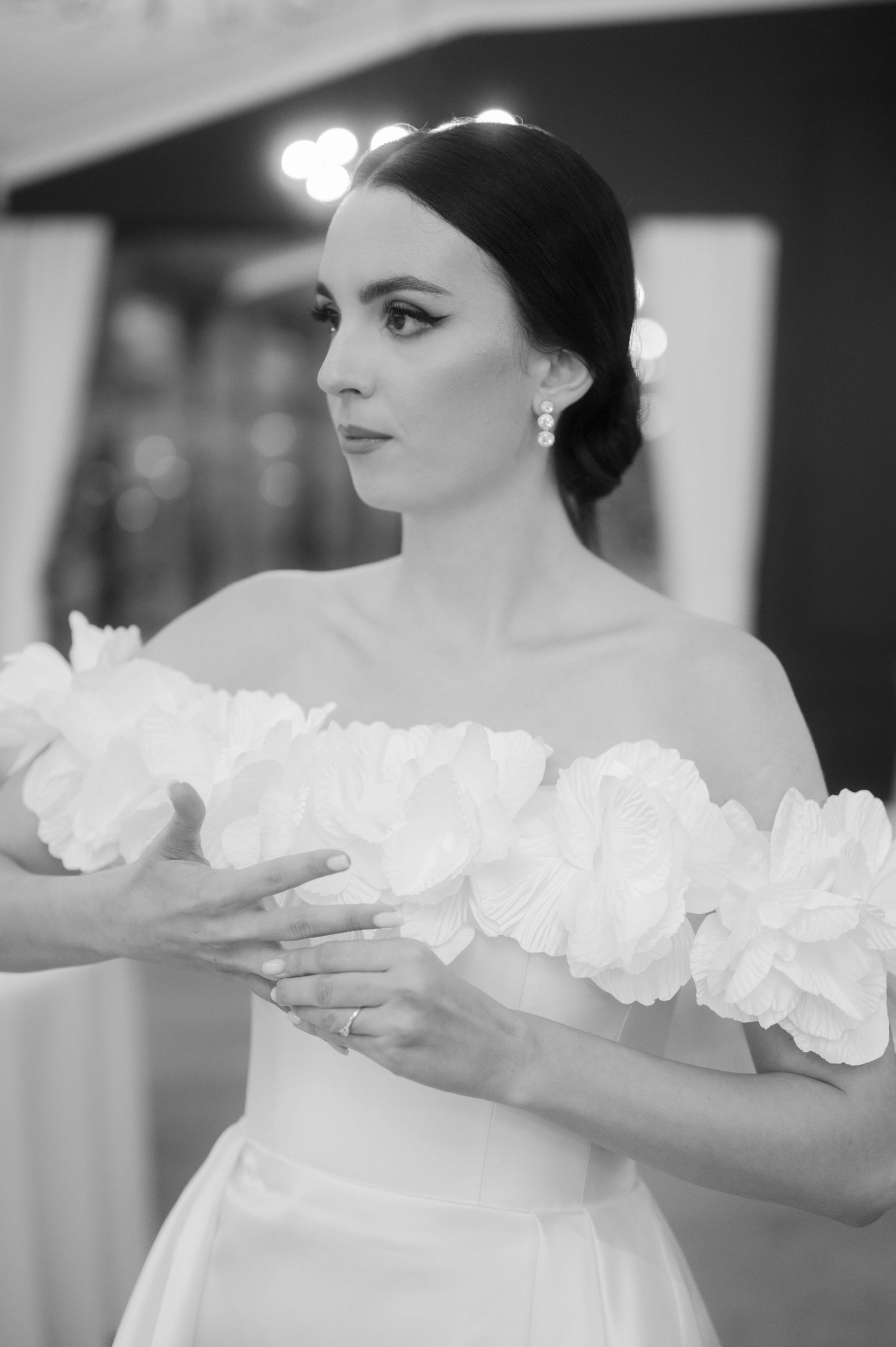 A black and white artistic portrait series showing delicate ruffled fabric details on a formal gown.