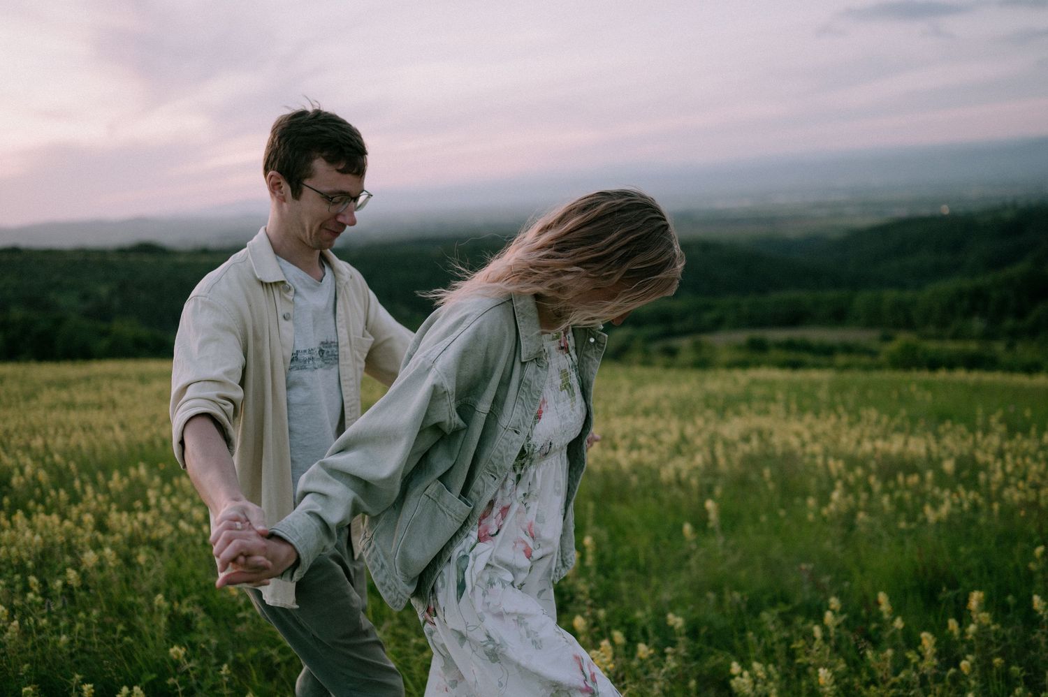 A playful dance scene unfolds in a wildflower meadow during golden hour.