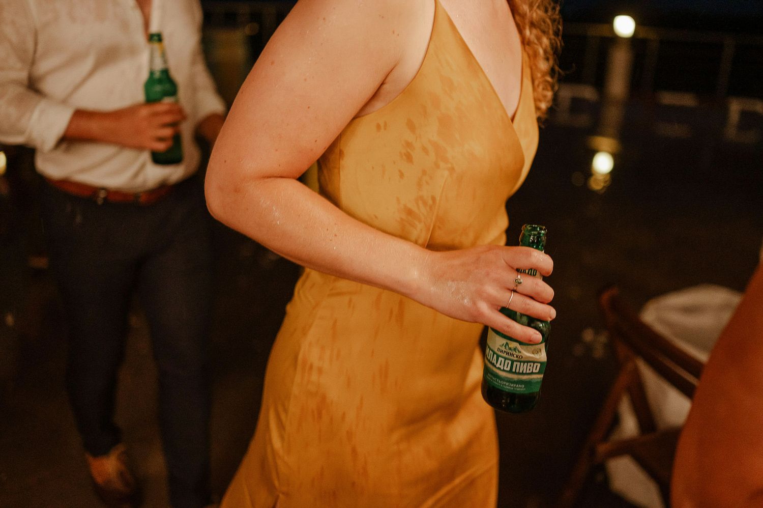 Guests in formal attire mingle and dance at an evening wedding reception.