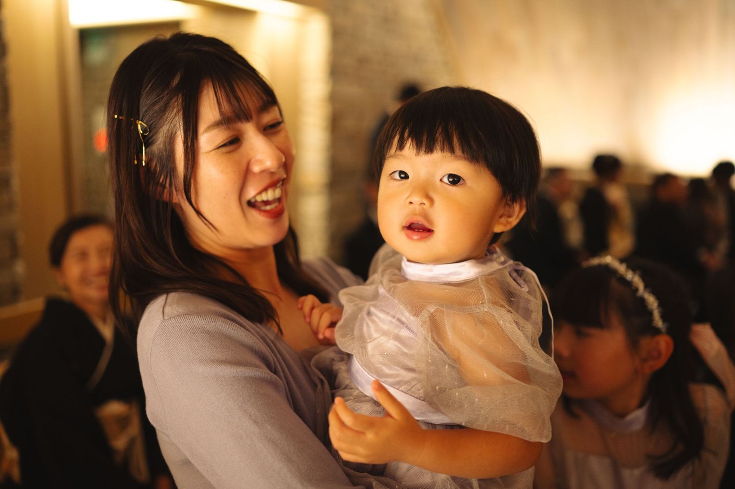 Happy guests celebrate at an elegant wedding reception with warm lighting and festive atmosphere.